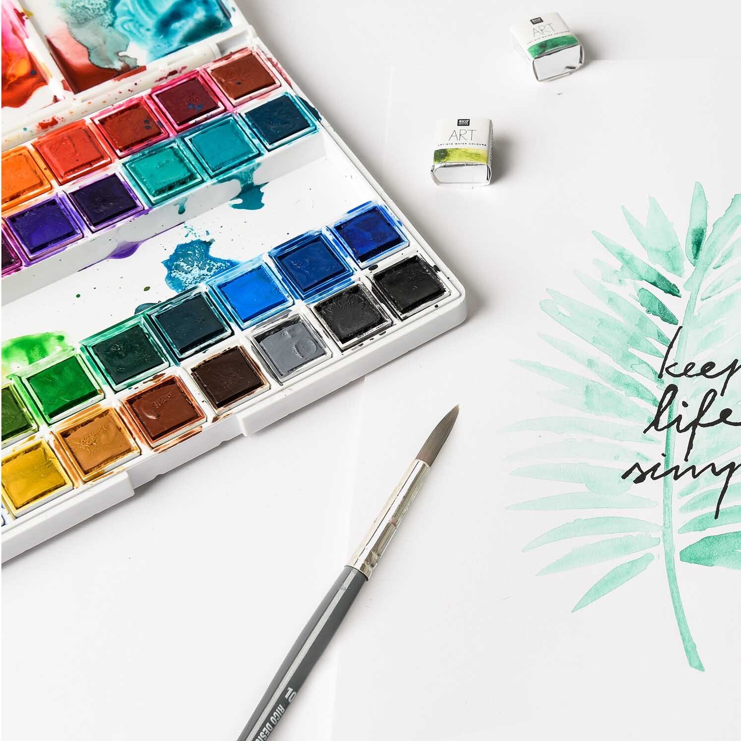 ART Künstler Aquarellfarben 36 Farben mit Pinsel und gemaltem Blattmotiv auf weißem Papier.