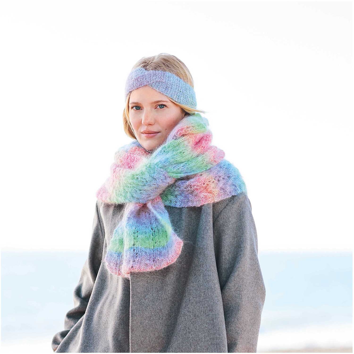 Fashion Mohair Rainbows: Frau mit pastellfarbenem Schal und Stirnband von Rico Design am Strand.