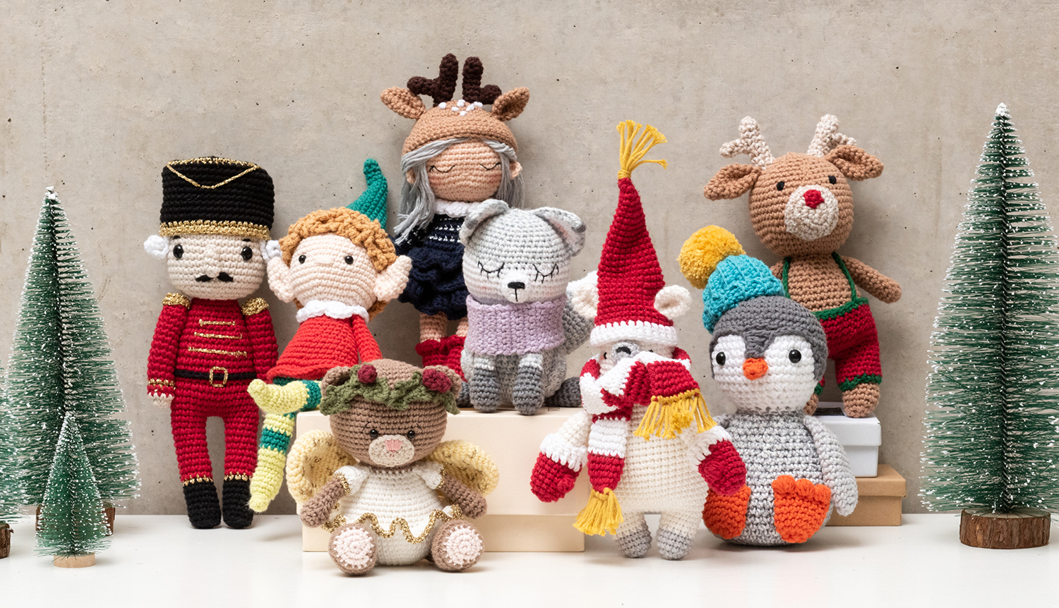 Häkelanleitung Ricorumi Teddyengel: Eine Gruppe bunter, gehäkelter Weihnachtsfiguren vor einem neutralen Hintergrund.