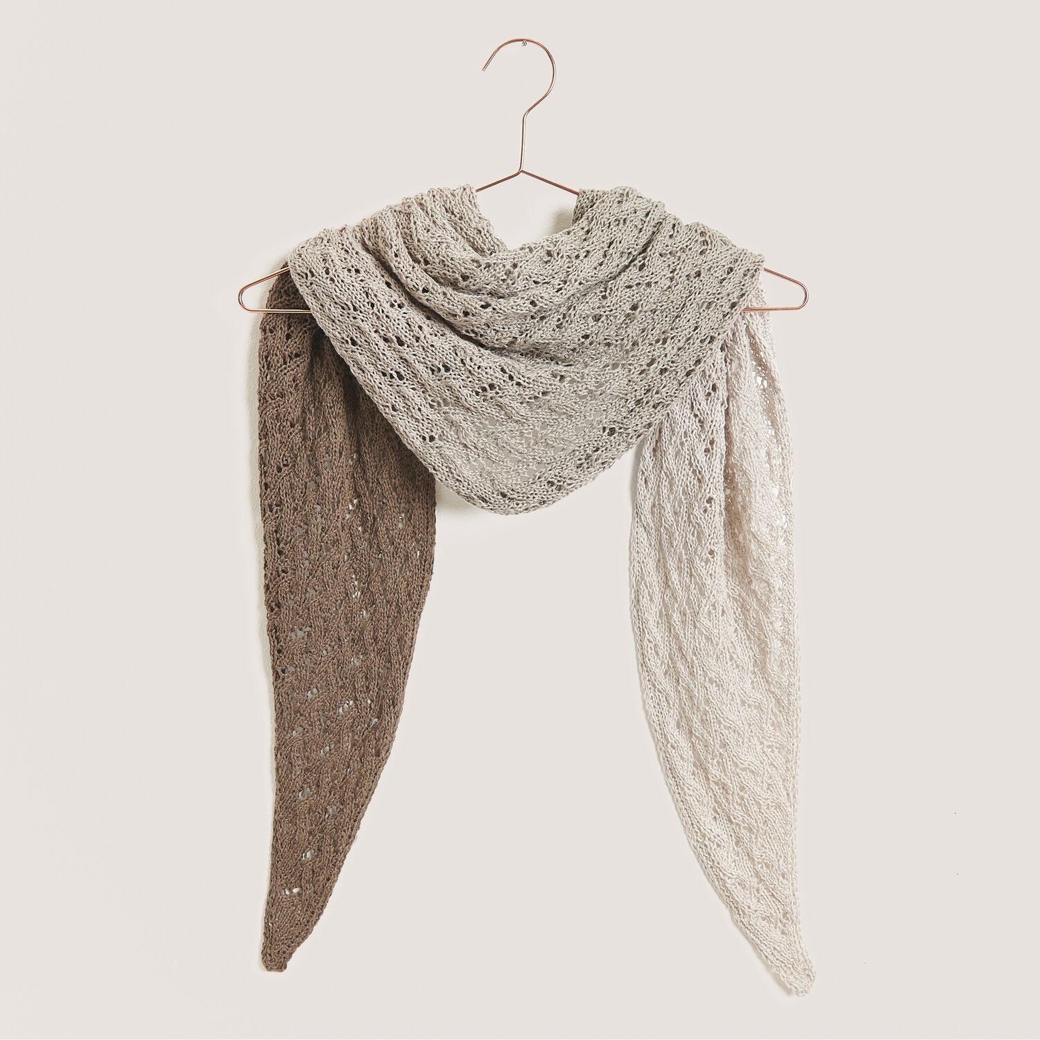 Strickset Dreieckstuch Modell 03 aus Tücher Special in Naturtönen, gehäkelt aus Creative Cotton Dégradé Lucky 8, hängt auf einem Kleiderbügel.