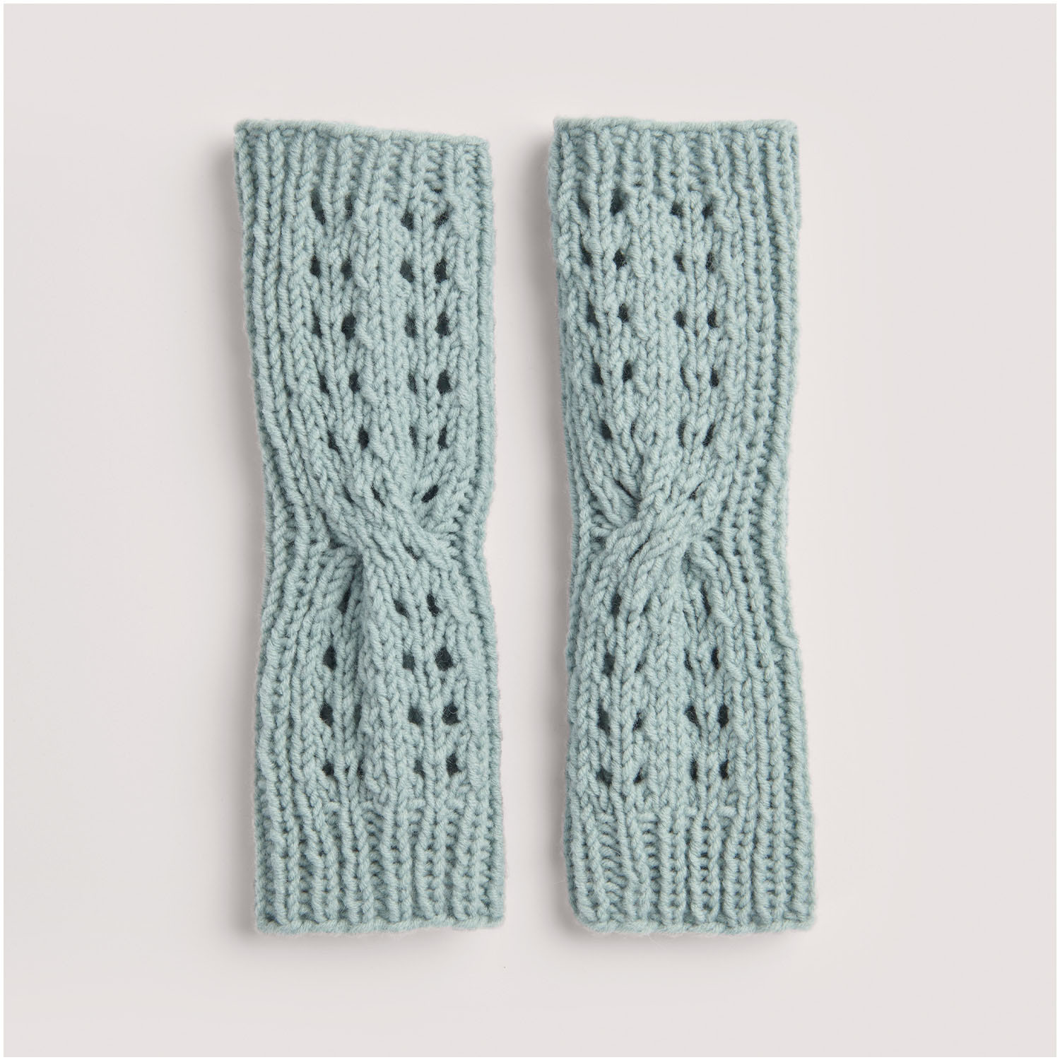 Strickset Armstulpen Modell 22: Hellblaue gestrickte Armstulpen mit Lochmuster, elegant und warm. Ideal für kühle Tage.