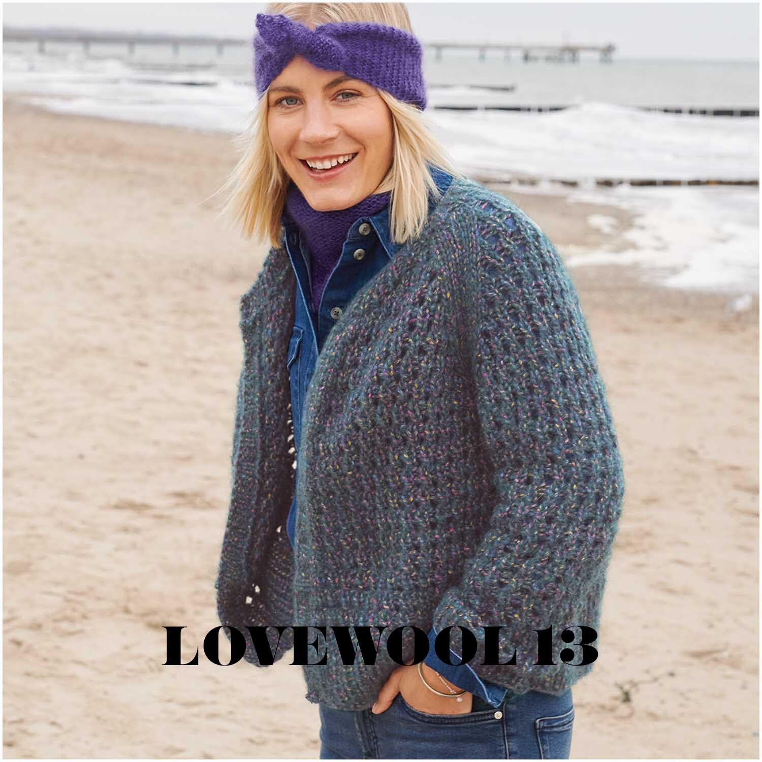 Fashion Alpaca BLING BLING: Frau am Strand in gestrickter Jacke in Petrol, lächelnd, mit lila Stirnband.