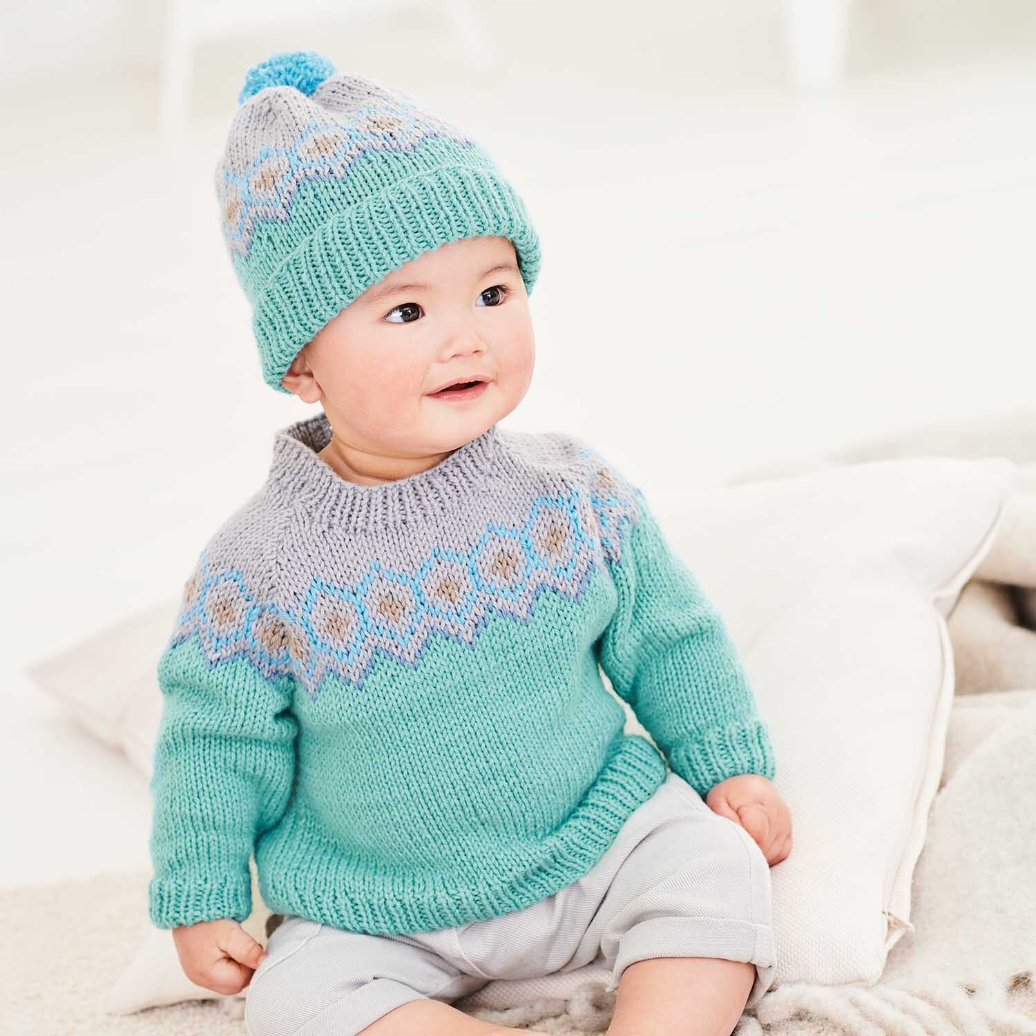 Strickanleitung Mütze und Pullover aus Rico Baby Dream dk Uni: Baby in mintgrünem Pullover und passender Mütze mit Muster.