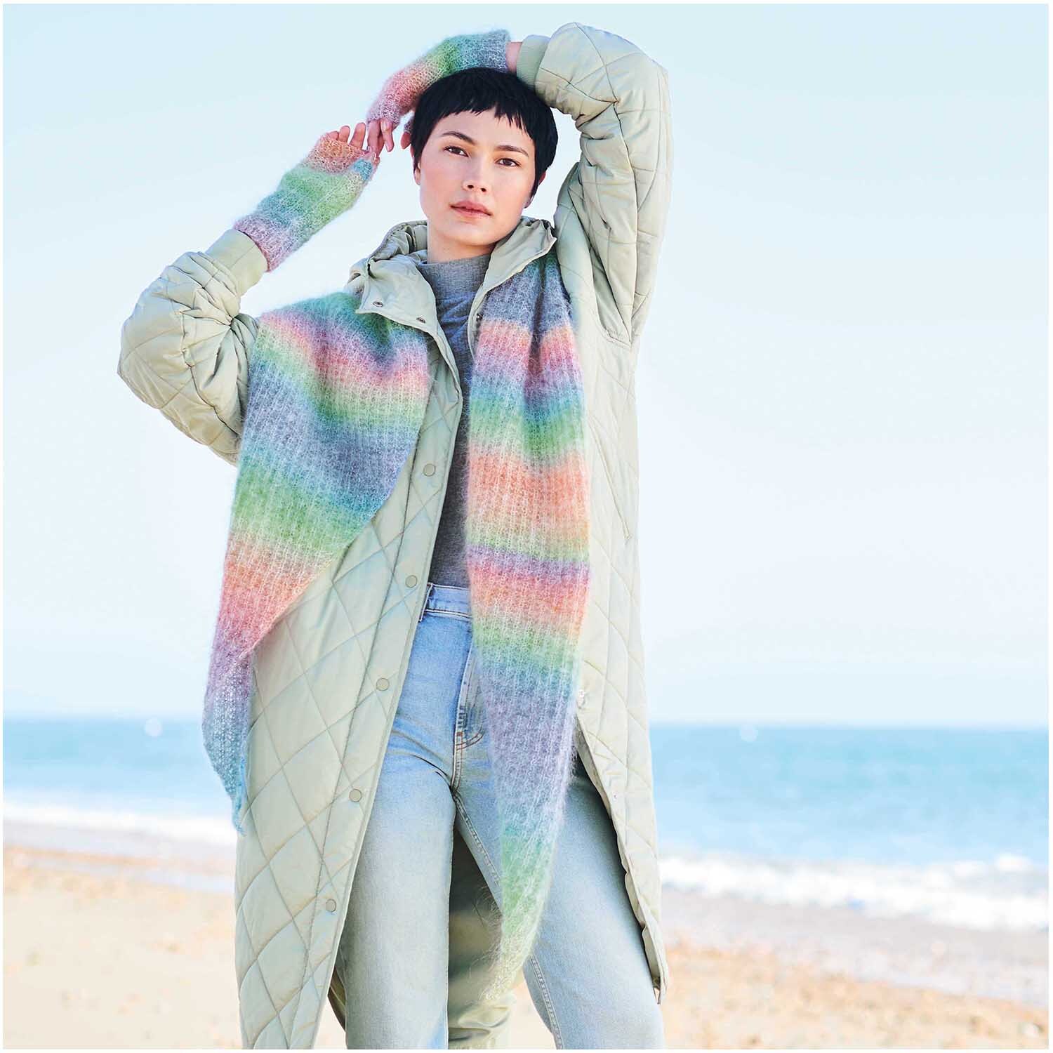 Fashion Mohair Rainbows: Person am Strand in pastellfarbenem Mantel von Rico Design, 25g 100m.