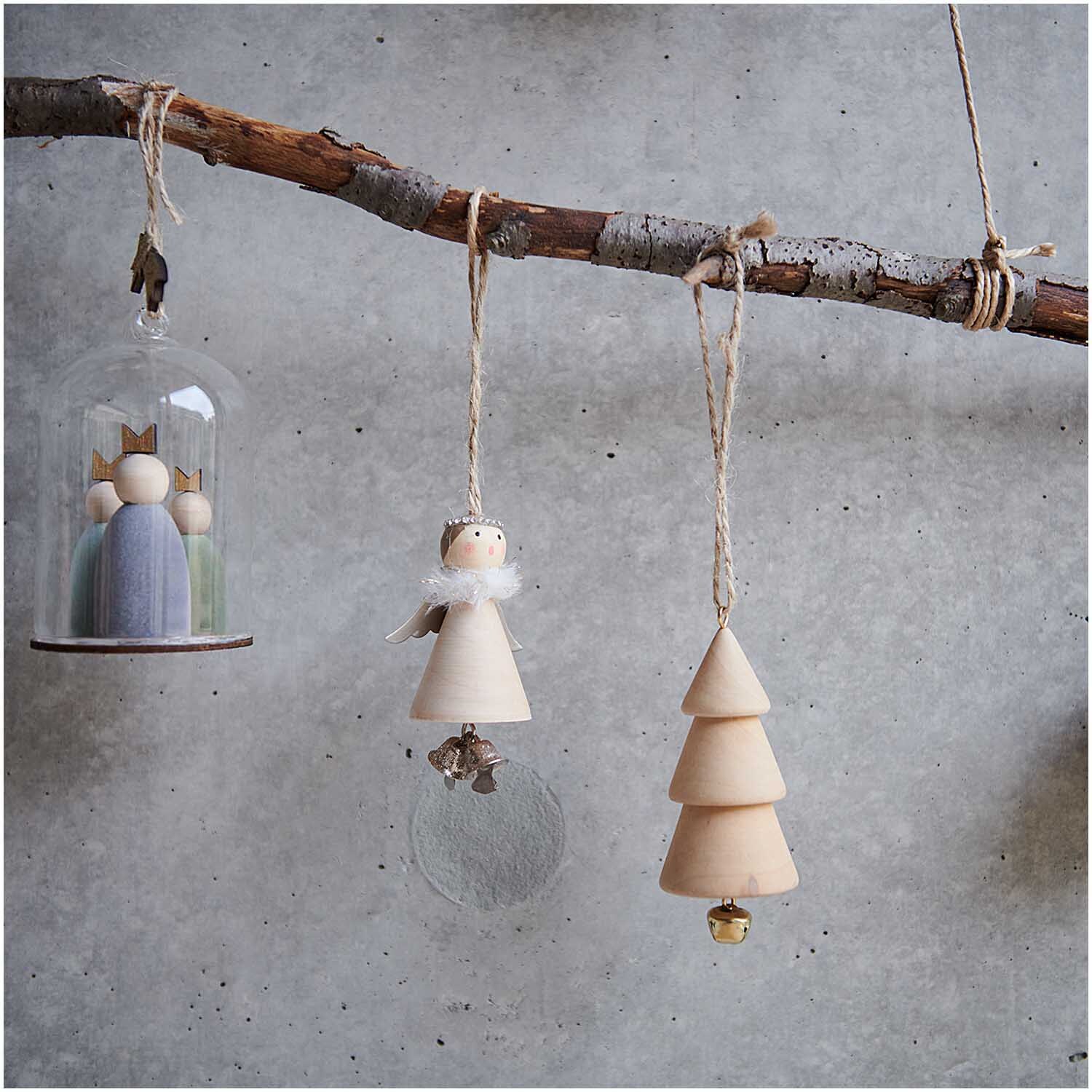 Holzhänger Tanne mit Glocke natur 4x9,5cm von Rico Design, dekorativ an einem Ast hängend.