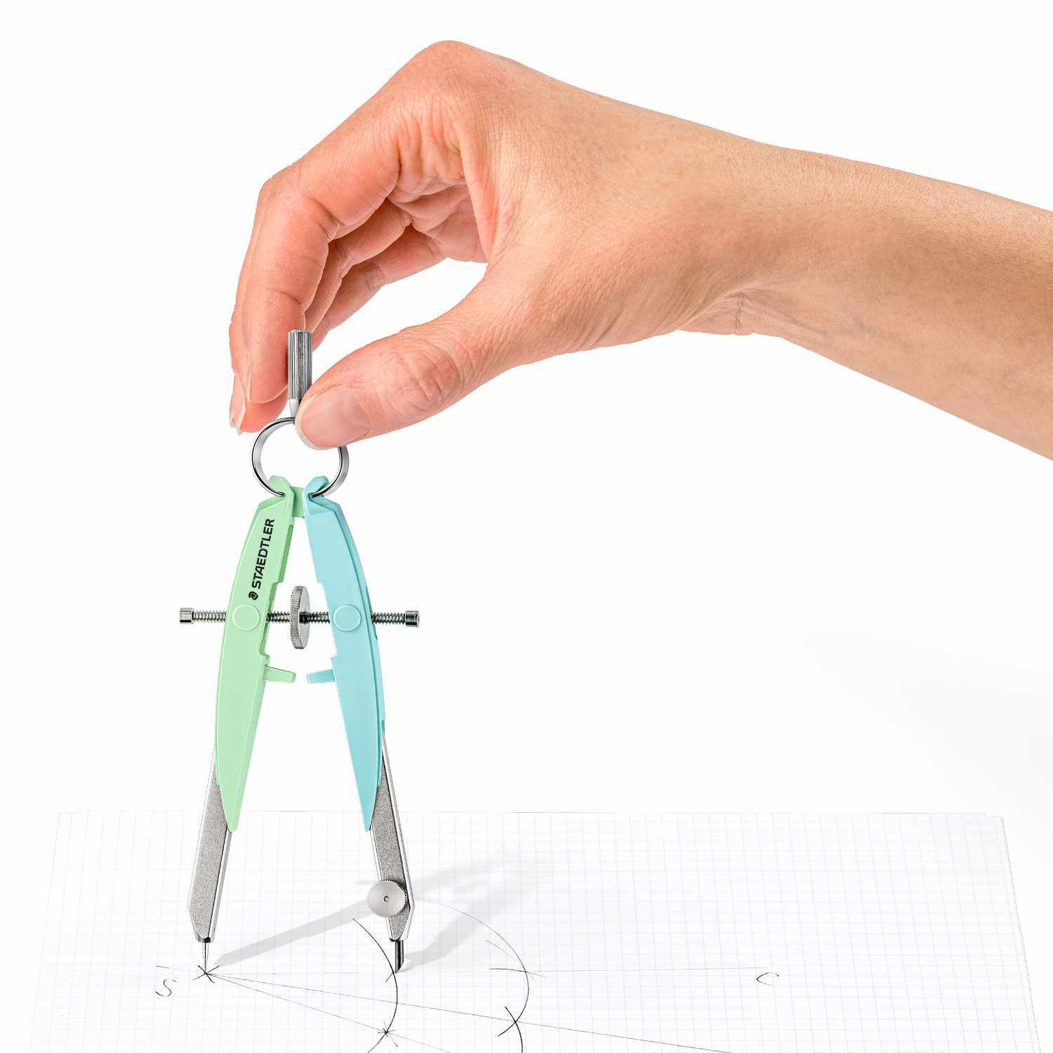 Mars Comfort Zirkel von Staedtler in Grün-Blau wird von einer Hand gehalten, während er auf Papier zeichnet.