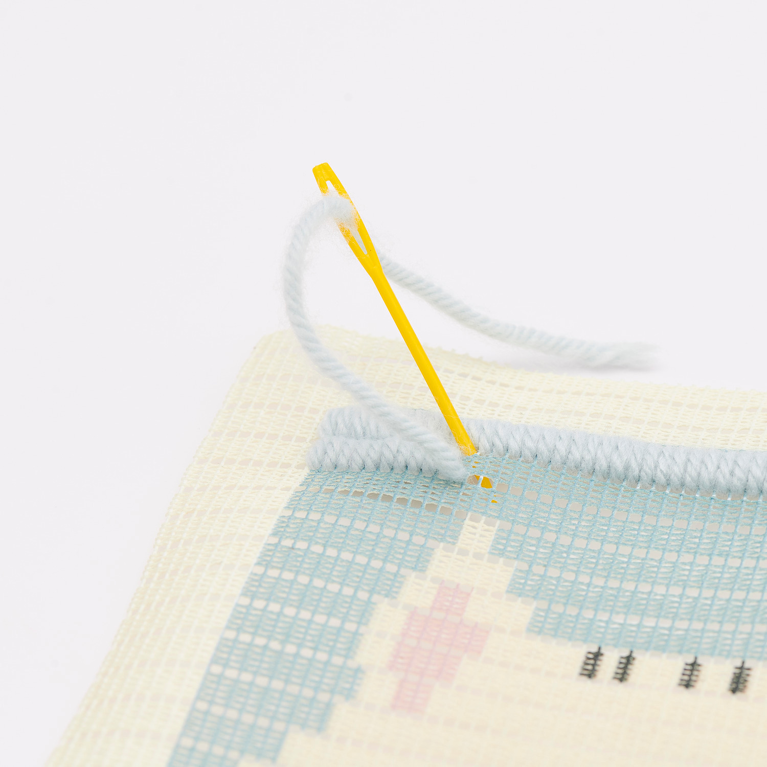 Longstitch Stickpackung Katze zeigt eine Nahaufnahme eines Stickprojekts mit Nadel und Faden.