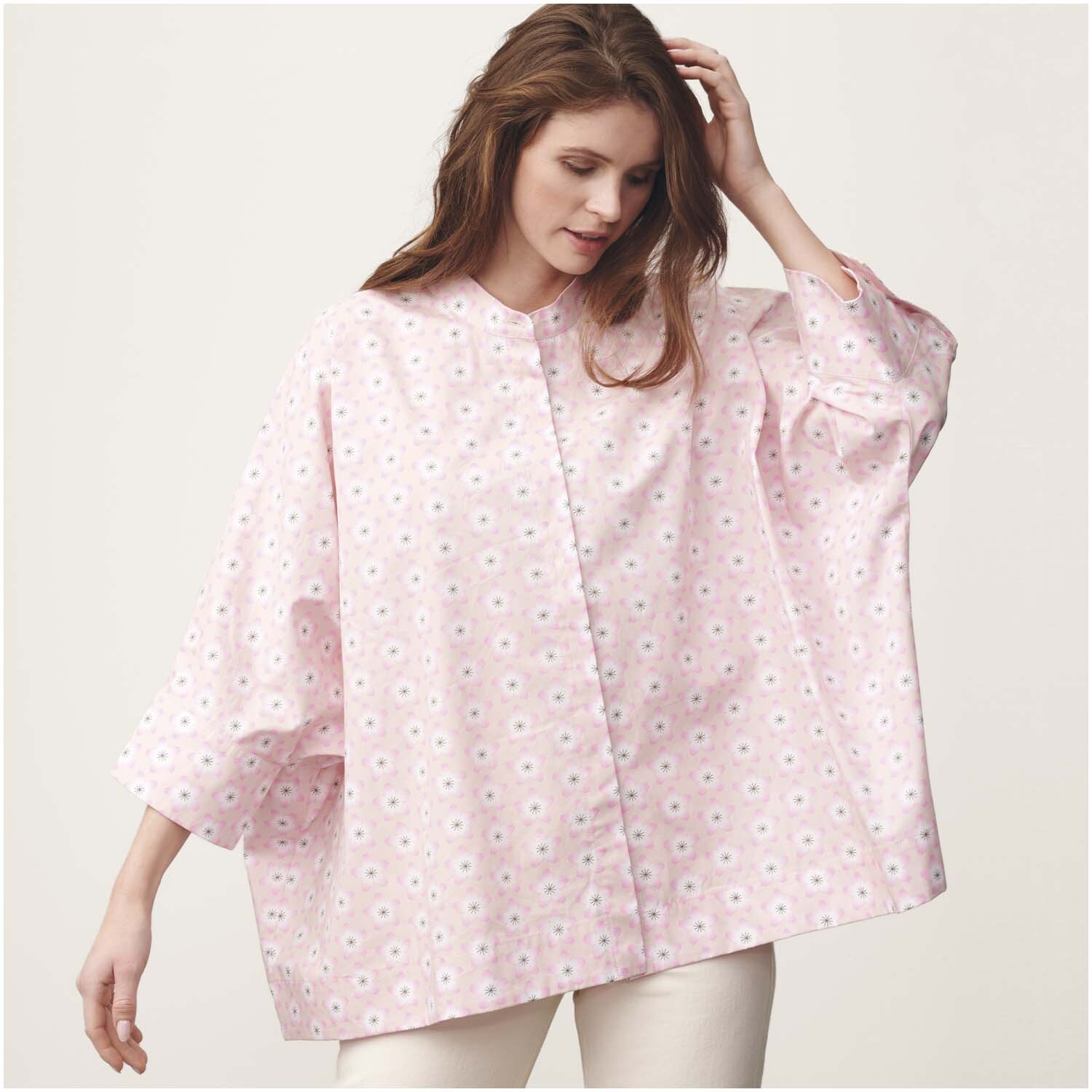Stoffabschnitt Baumwoll-Popelin rosa Kirschblüten 50x140cm: Frau trägt weite Bluse aus rosa Popelin mit Kirschblütenmuster von Rico Design.
