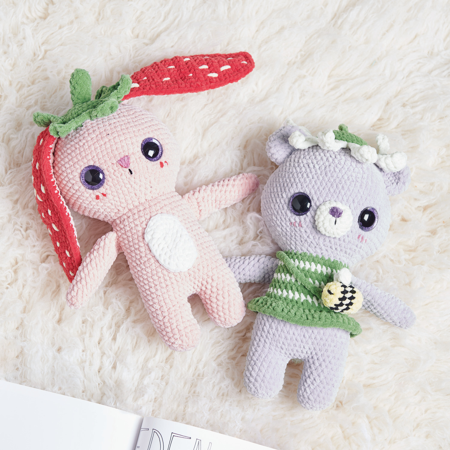 Häkelset Strawberry Bunny Modell 03: Rosa Hase mit Erdbeerohren, liegend auf flauschigem Teppich.