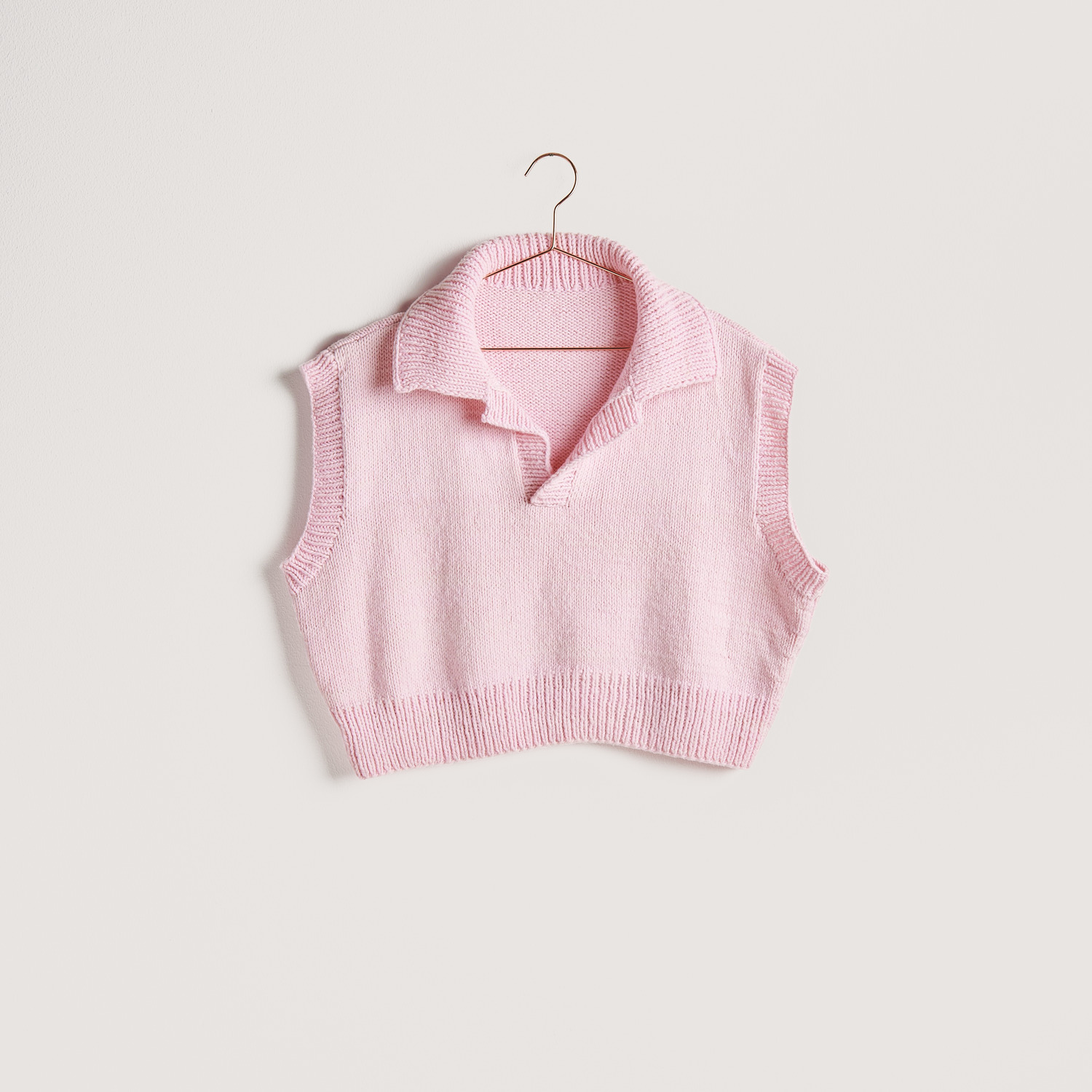 Strickset Pullunder Modell 10 aus Vegan Cashmere in zartem Rosa, präsentiert auf einem Kleiderbügel. Ideal für stilvolle, nachhaltige Mode.