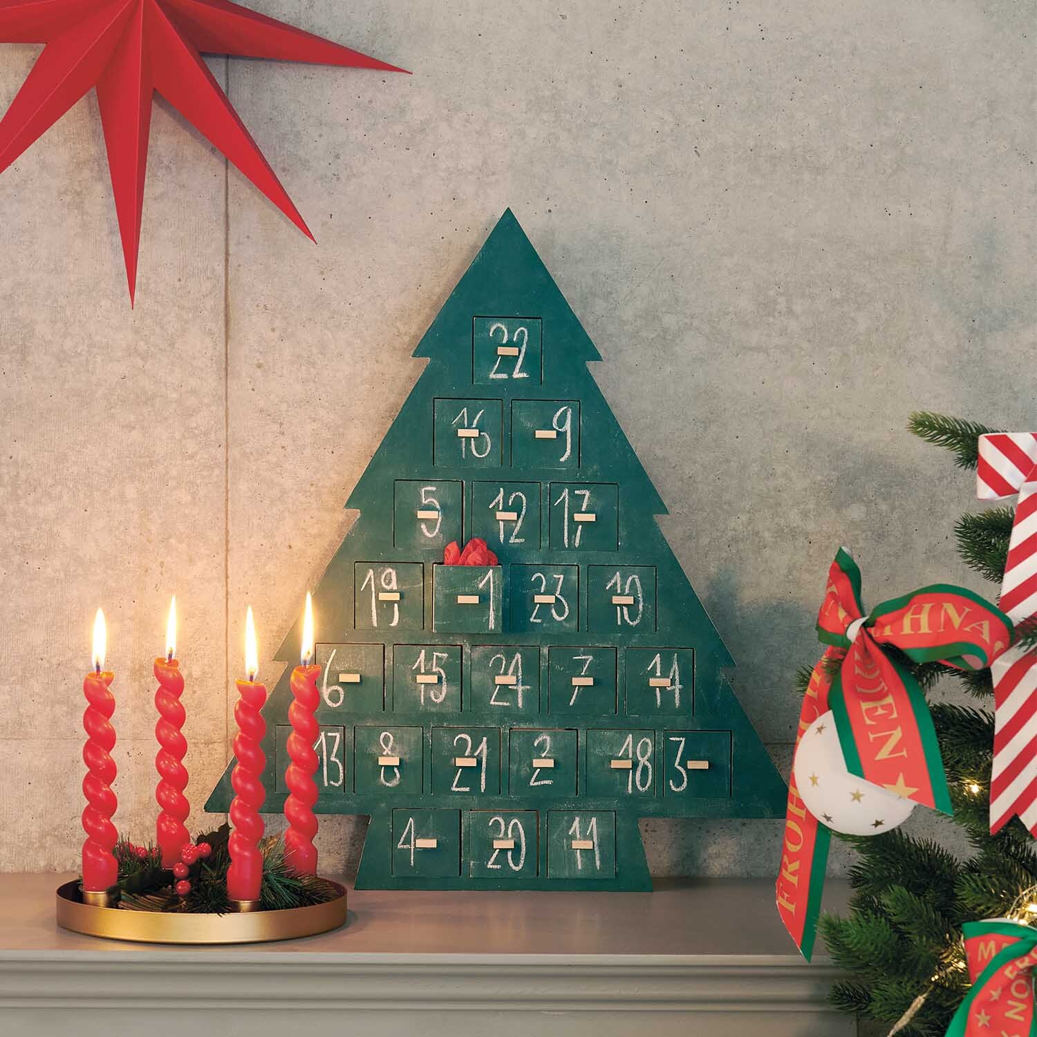 Anleitung Holz-Adventskalender in Shabby-Chic-Look: Grüner Baum mit weißen Zahlen, dekoriert neben roten Kerzen und Weihnachtsbaum.