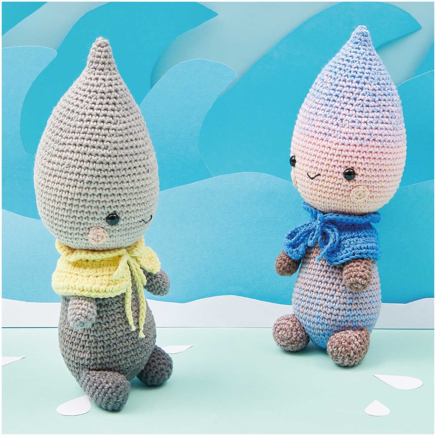 Creative Ricorumi dk: Zwei gehäkelte Figuren mit spitzen Hüten, eine in Grau mit gelbem Schal, die andere in Blau mit blauem Schal, vor blauem Hintergrund.