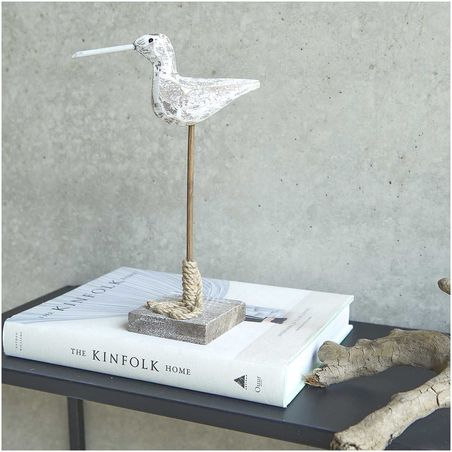 Aufsteller Möwe shabby chic weiß-grau 16x8,5cm auf einem Tisch, dekoriert mit Büchern und Holz.