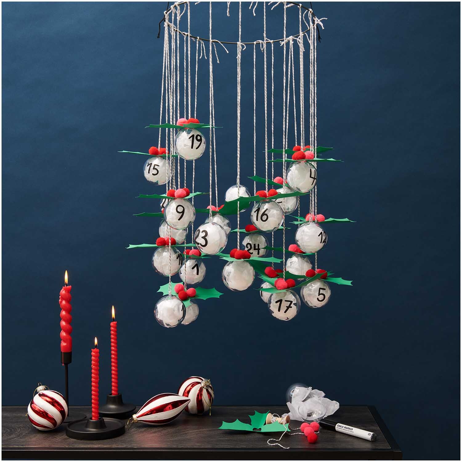 Bastelanleitung Adventskalender aus Acrylkugeln: Hängender Kalender mit nummerierten Kugeln und roten Akzenten, ideal für kreative Weihnachtsdekoration.