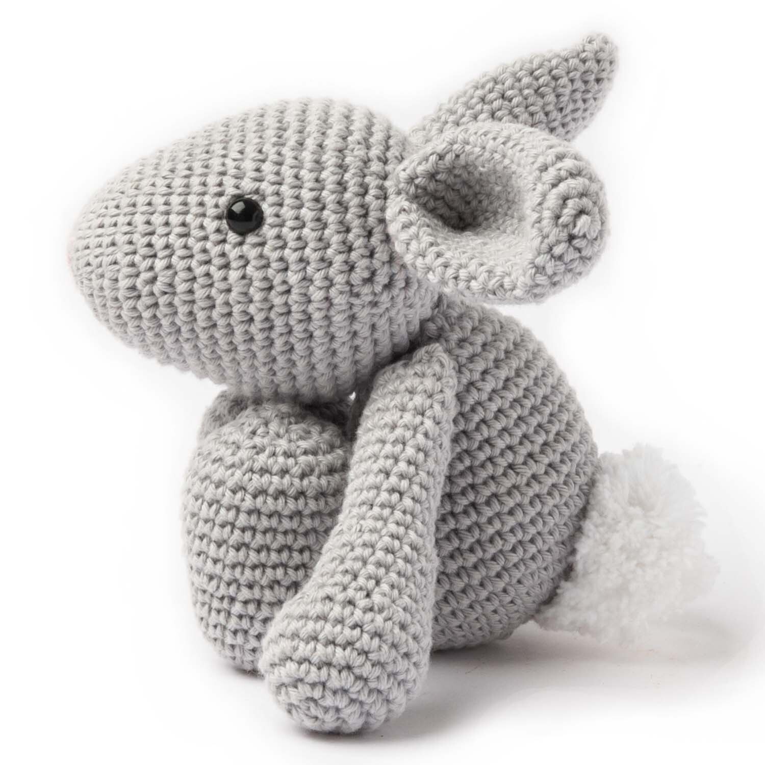 Häkelset Ricorumi Puppies Hase: Ein grauer, gehäkelter Hase von Rico Design mit flauschigem Schwanz.