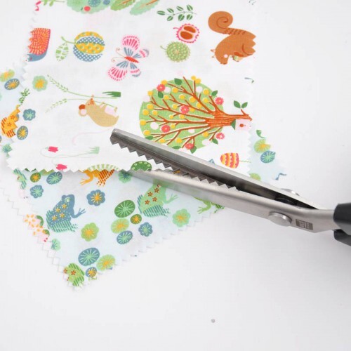 Stoffschere Zick-Zack 21cm schneidet gemusterten Stoff mit Tiermotiven. Marke: Rico Design. Ideal für kreative Nähprojekte.
