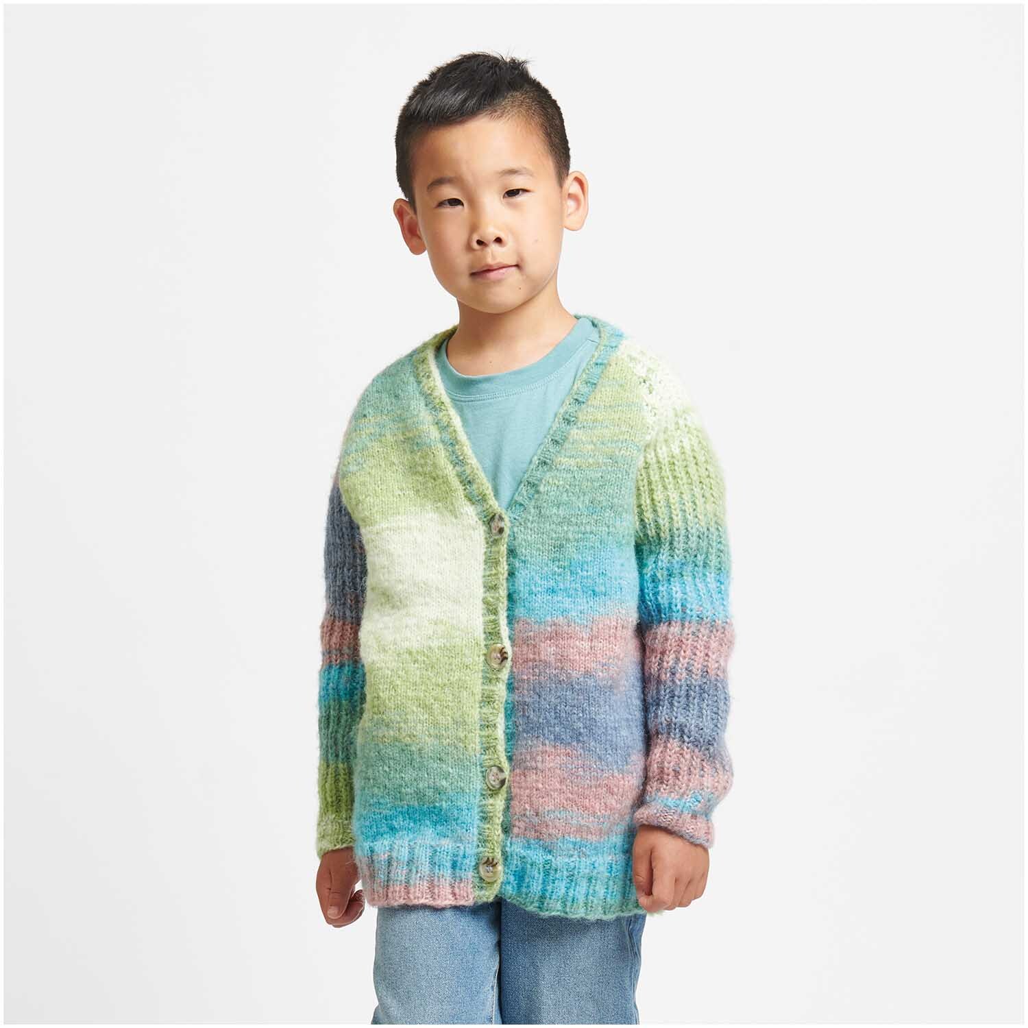 Creative Painted Power: Kind trägt gestrickte, bunte Strickjacke von Rico Design in Pastelltönen.