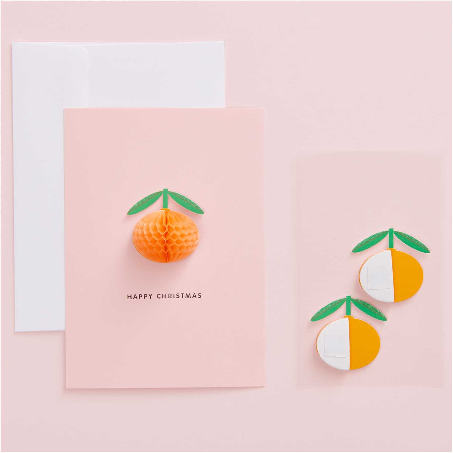 Paper Poetry Wabenpapiersticker Orangen auf rosa Karte mit grünem Blattdesign, ideal für kreative Weihnachtsdekorationen.