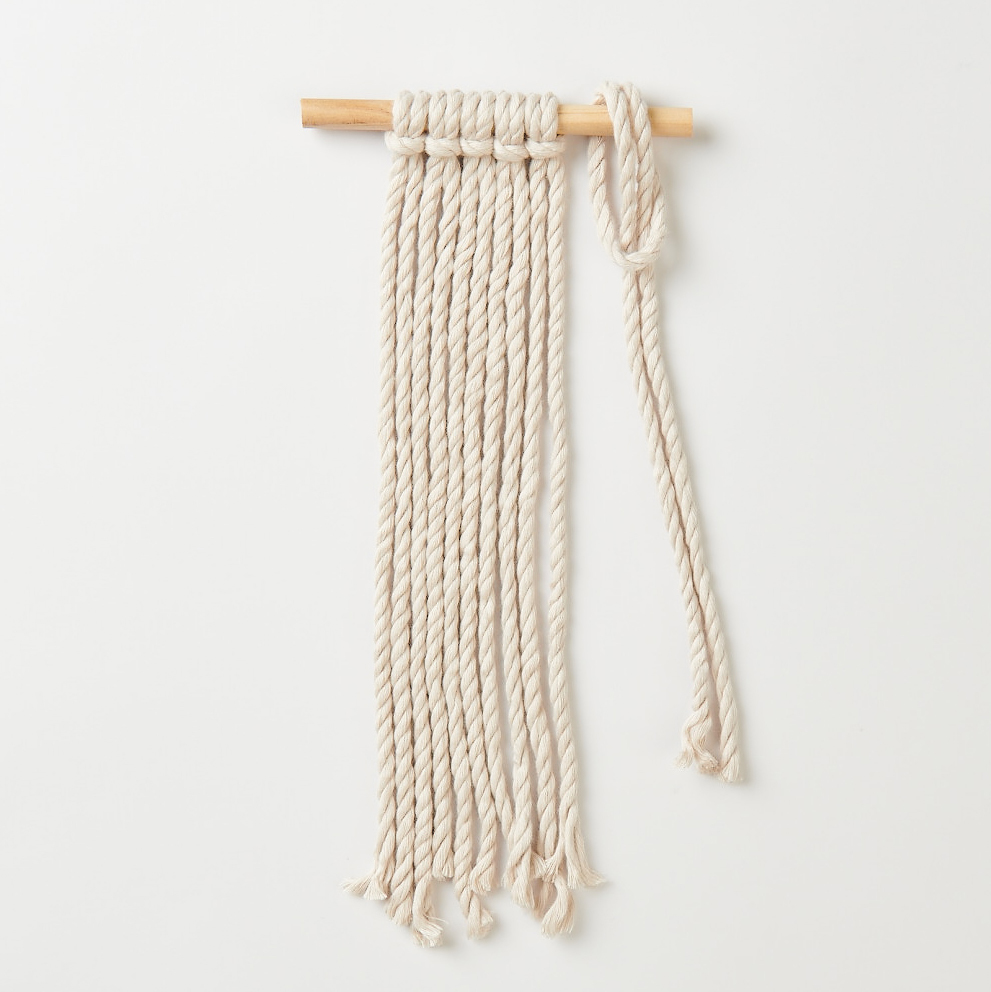 Makramee Set Wandbehang von Rico Design: Eleganter Wandbehang aus cremefarbenem Seil auf Holzstab. Ideal für stilvolle Wohnakzente.