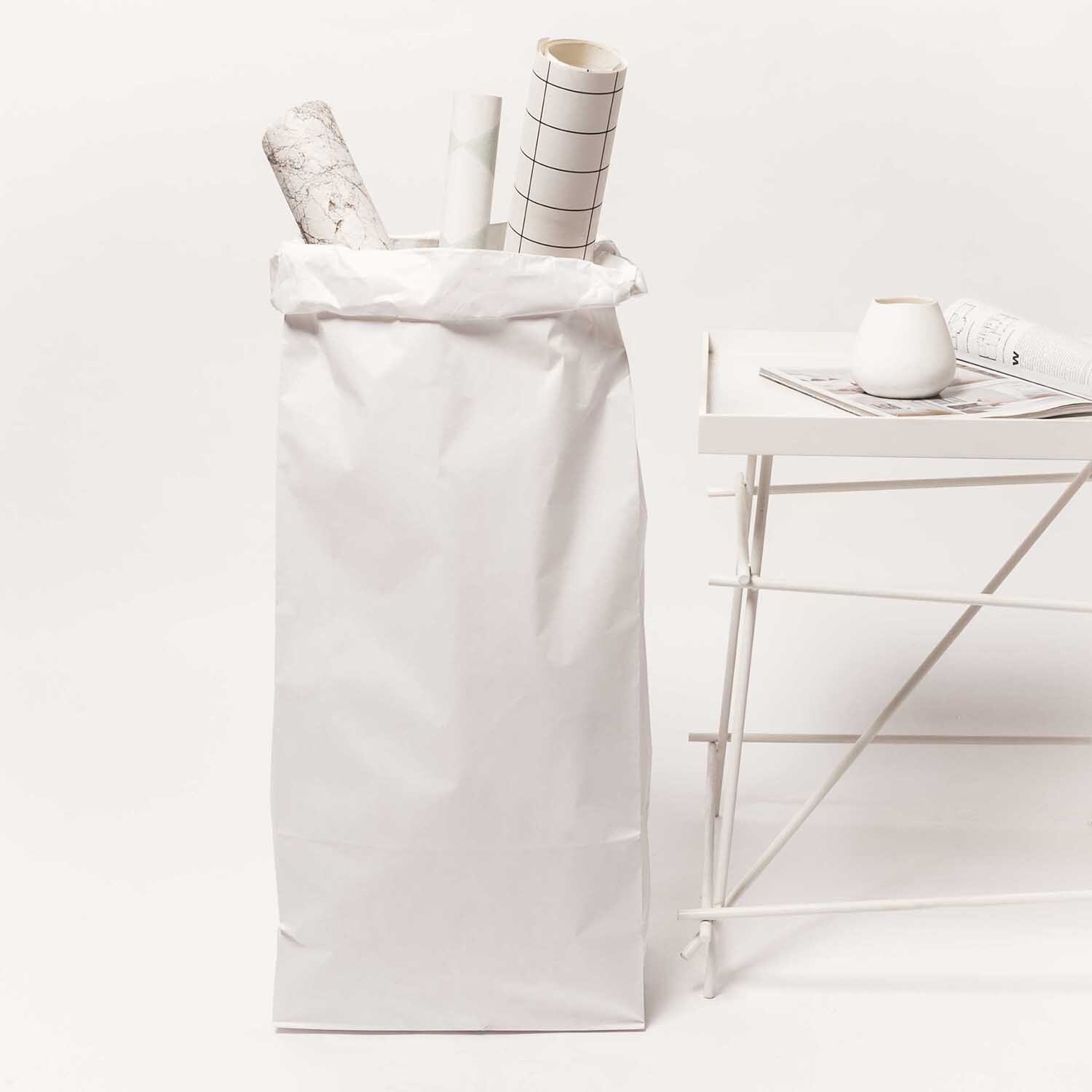 Paper Poetry Maxi-Blockbodenbeutel XL in Weiß neben einem Tisch mit Deko und Zeitschriften.