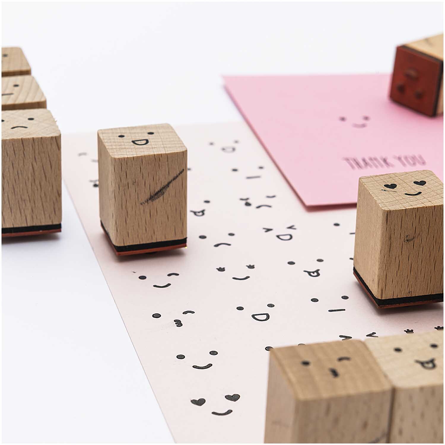 Paper Poetry Stempelset Smile: 13-teiliges Set von Rico Design mit Holzstempeln und lächelnden Gesichtern auf Papier.