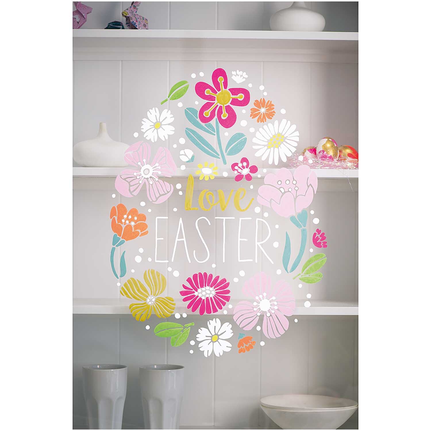 Vorlagenmappe Ostern Fenster- und Glasmalerei zeigt bunte Blumen und den Schriftzug "Love Easter" auf einem Regal.