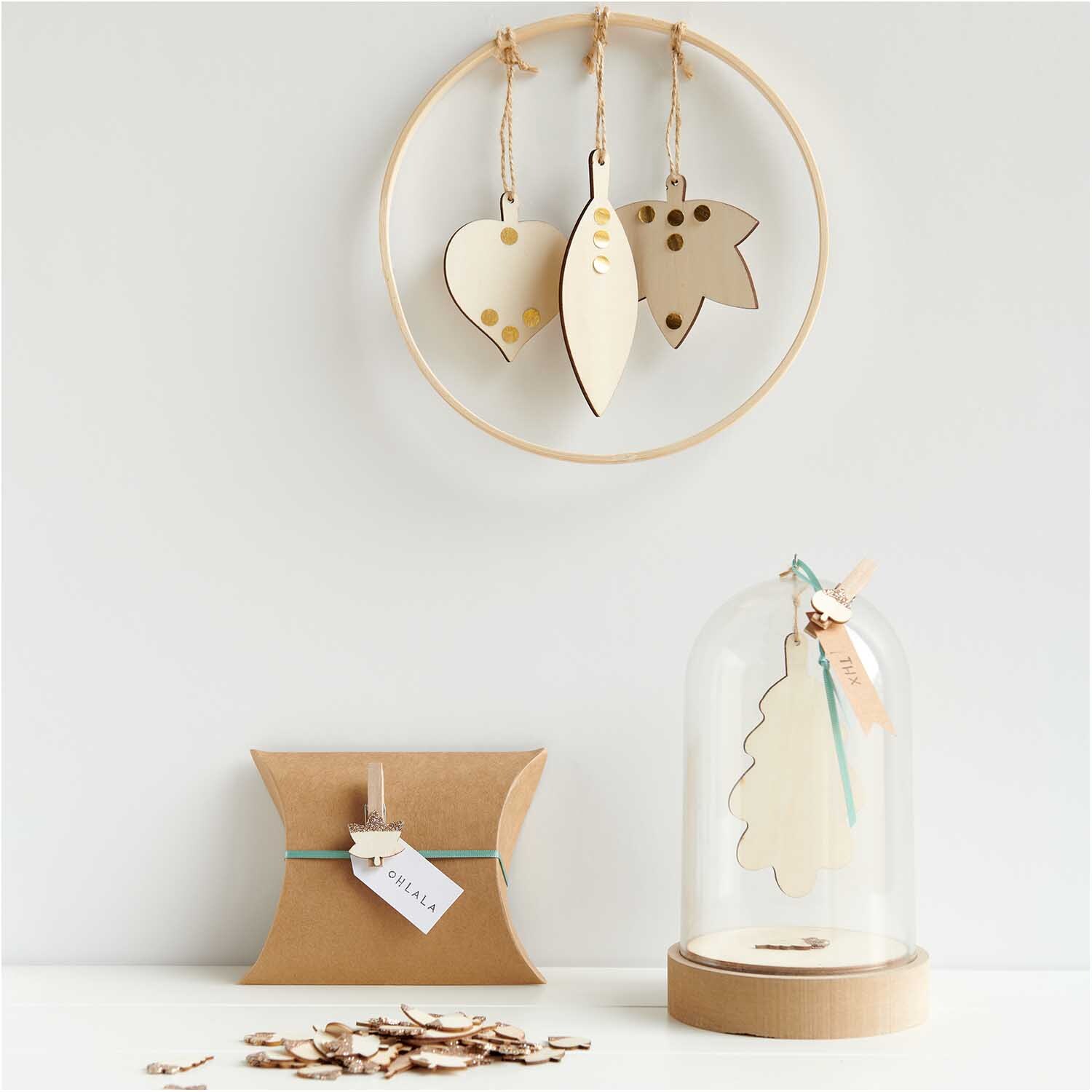 Holzanhänger Ahornblatt natur von Rico Design, dekorativ an einem Holzring hängend, mit weiteren Blattformen in einem minimalistischen Arrangement.