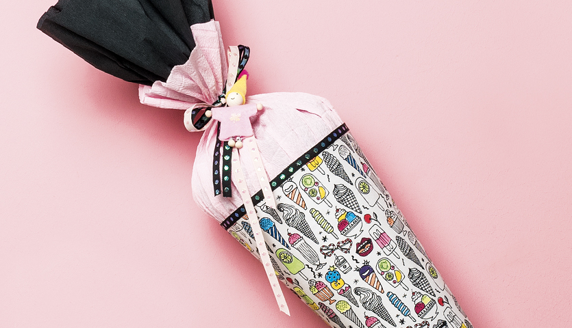 Bastelanleitung Schultüte aus Stoff: Bunte Schultüte mit Eiscreme-Muster auf rosa Hintergrund.
