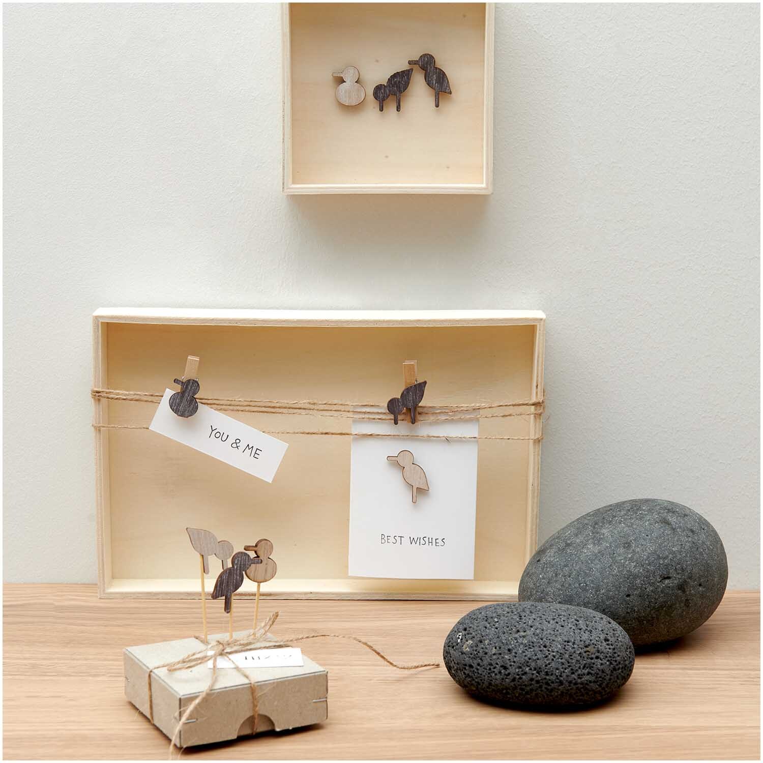 Holzsticker Möwe Mix natur 27 Stück von Rico Design: Dekorative Möwensticker in Holzoptik, präsentiert auf einem Tisch mit Steinen und Karten.