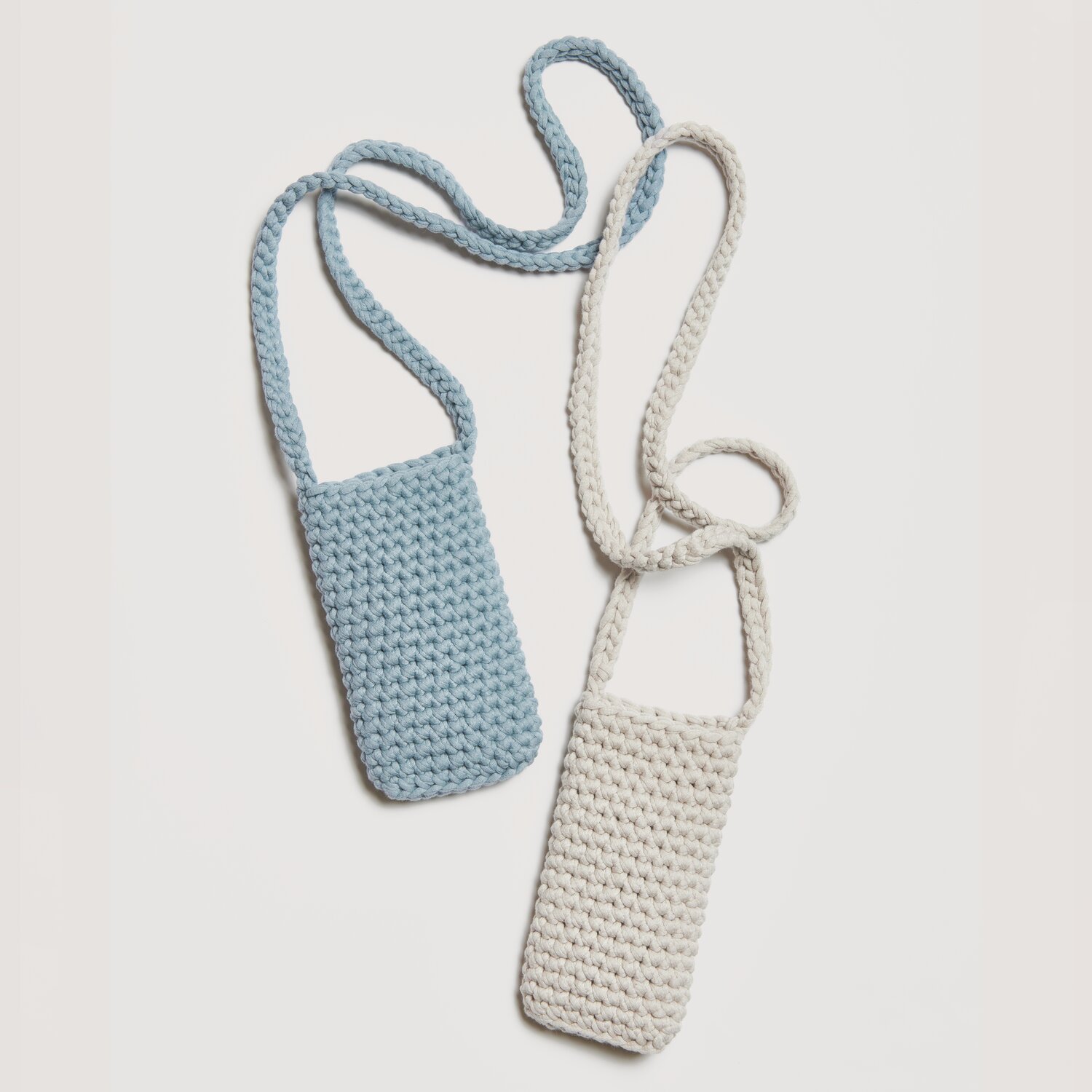 Made by Me No. 20 Frühjahr-Sommer: Zwei gestrickte Handyhüllen in Blau-Grau und Silbergrau, verbunden durch lange Träger.