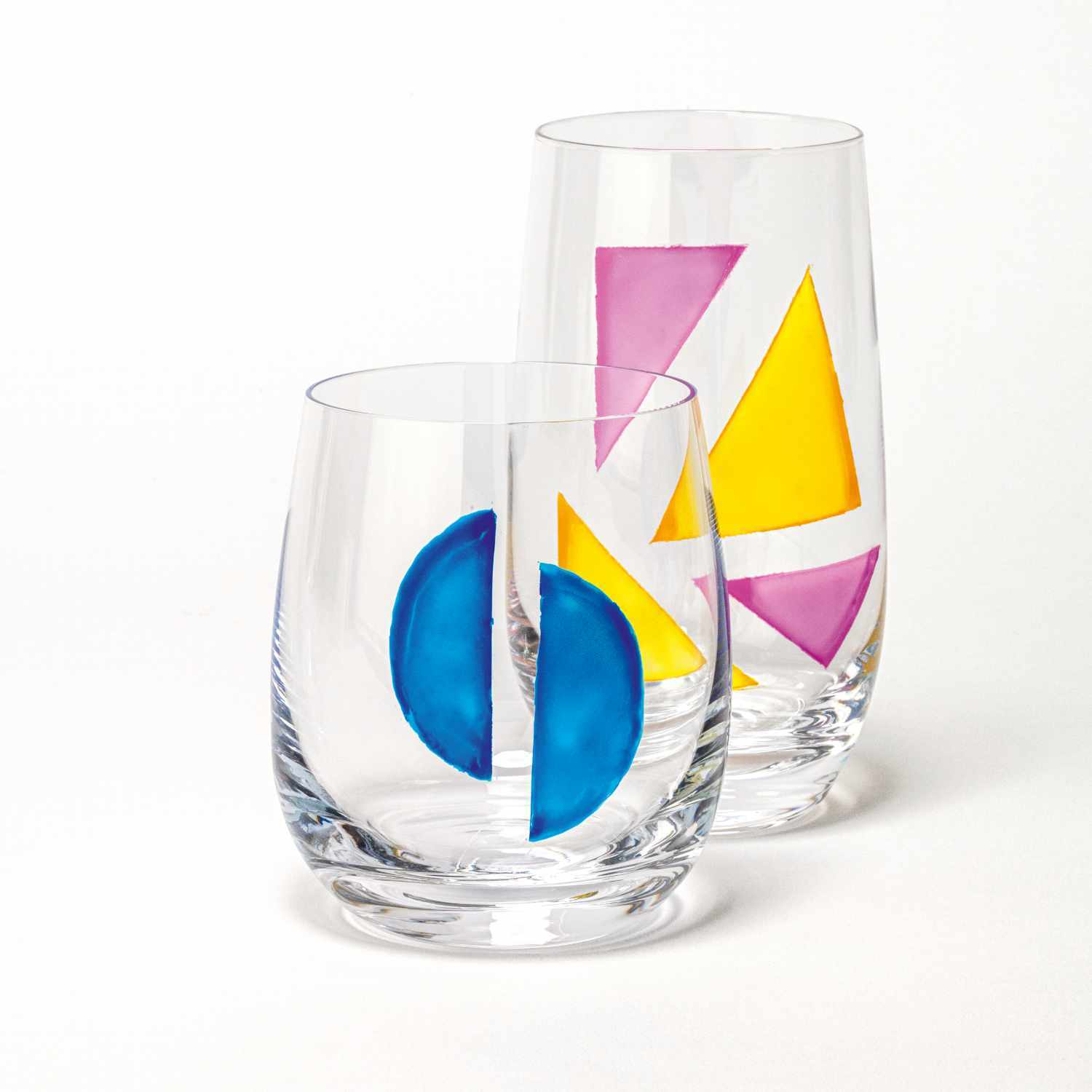 Porcelain & Glass Starterset matt, 7-teilig: Zwei Gläser mit bunten geometrischen Mustern in Blau, Gelb und Pink auf weißem Hintergrund.