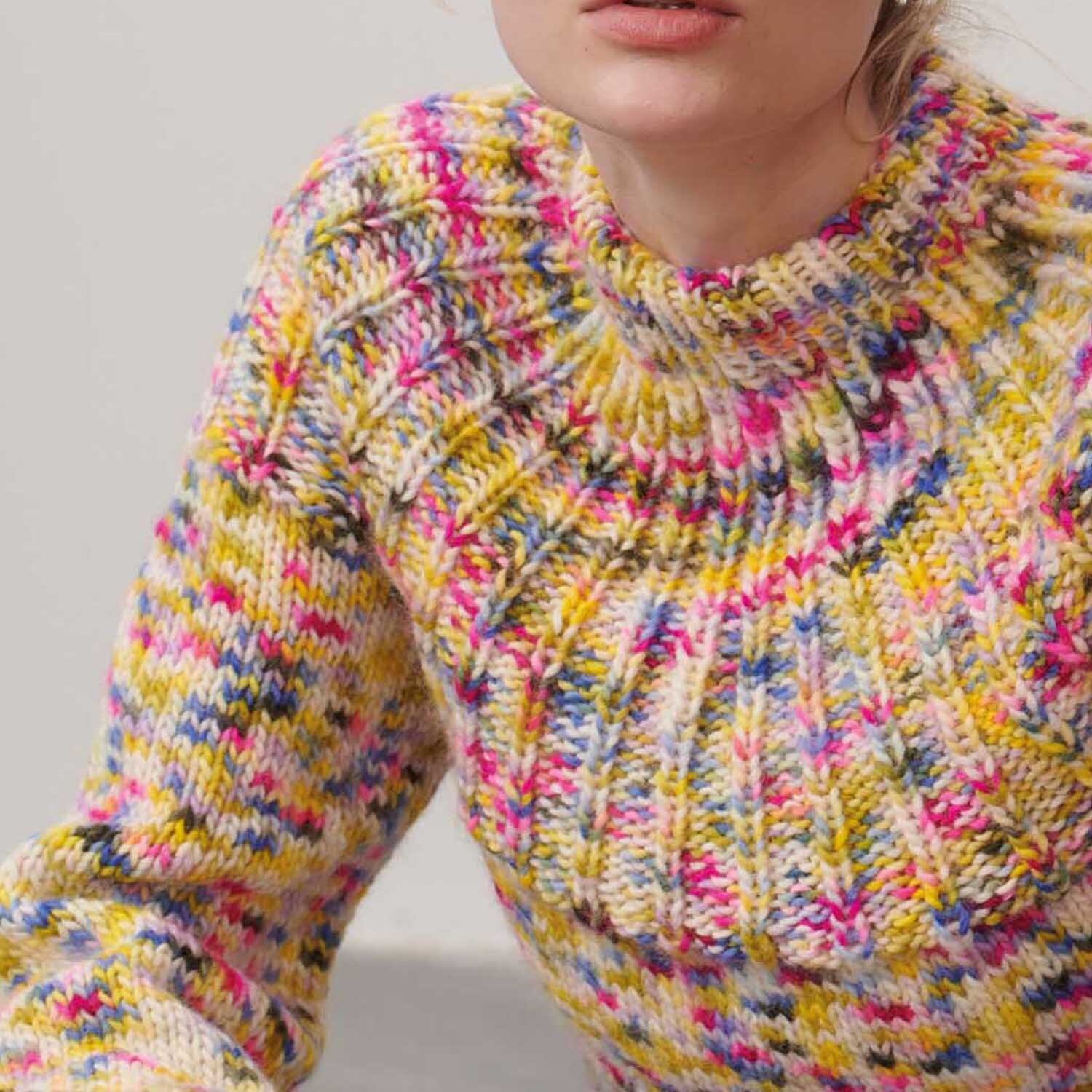 Luxury Hand-Dyed Happiness chunky: Frau trägt gestrickten Pullover in Pink-Gelb von Rico Design, 100g 170m.
