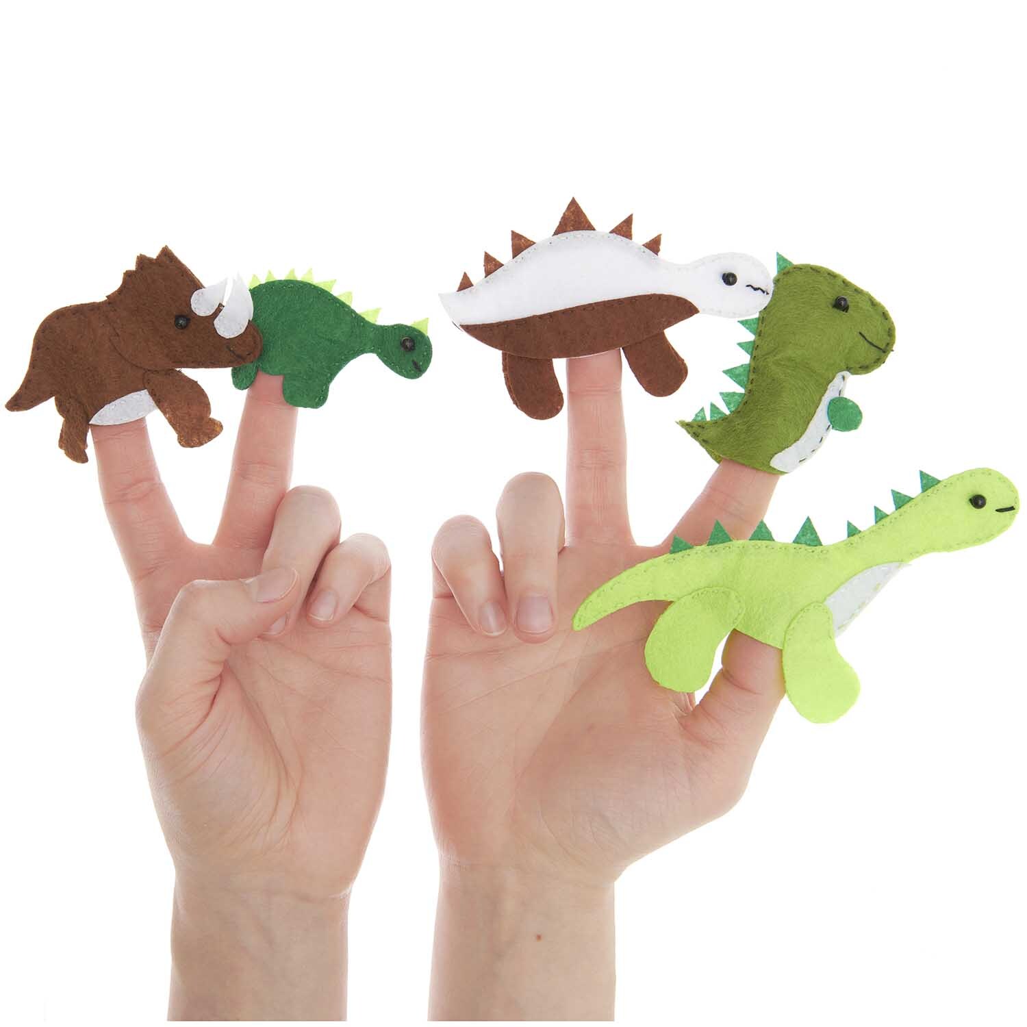 Bastelset Filz Fingerpuppen Dinosaurier 5 Stück: Fünf bunte Dinosaurier-Fingerpuppen auf Händen. Ideal für kreatives Spiel.