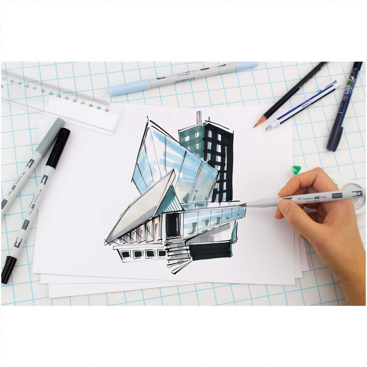 ABT PRO Warm Grey Colours Alkoholbasierte Marker von Tombow, 5-teilig, beim Zeichnen einer modernen Architektur auf kariertem Papier.