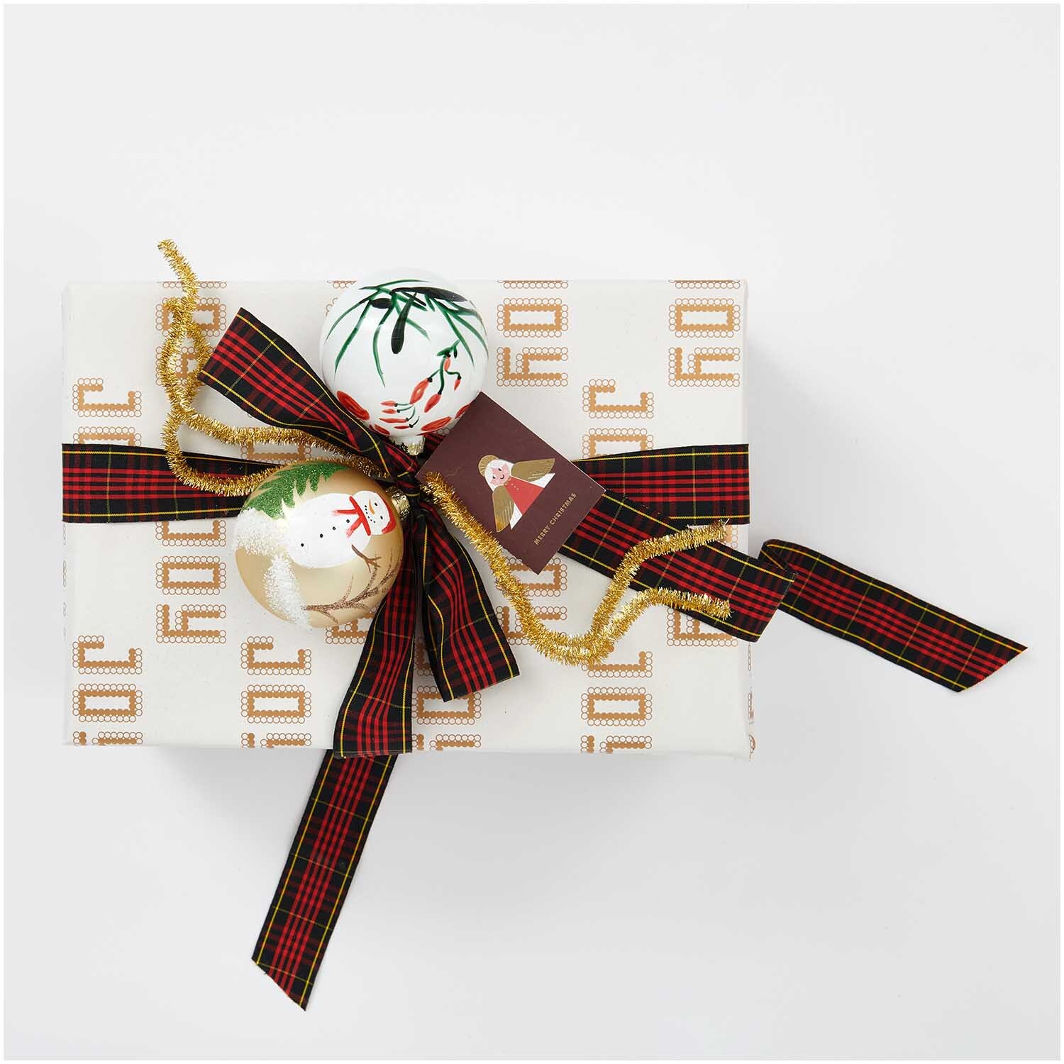 Glaskugel Schneemann handbemalt gold 8cm von Rico Design, dekoriert auf einem Geschenk mit Schleife.