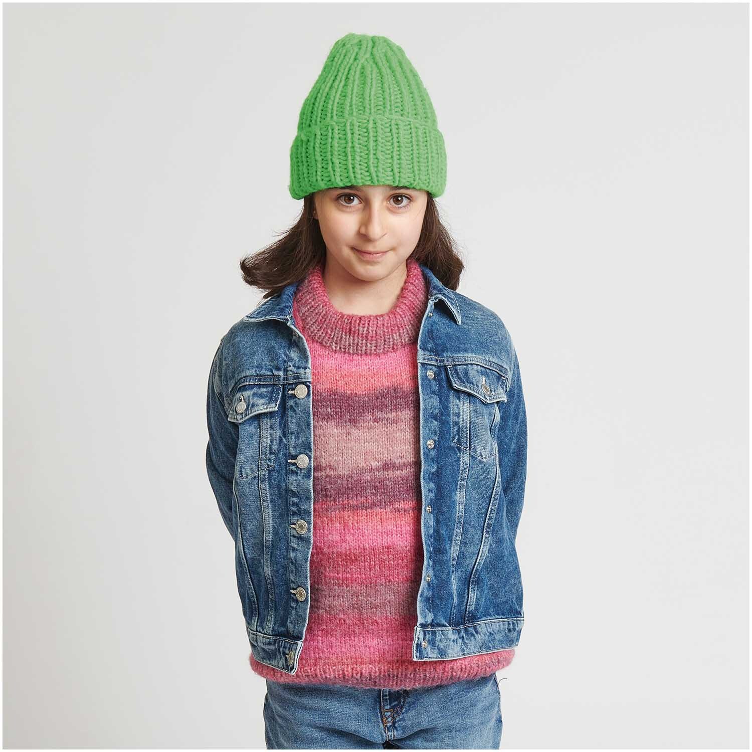 Strickset Pullover Modell 11 aus Kids Nr. 12: Mädchen in Jeansjacke und grünem Strickmütze, trägt gestreiften Pullover in Rosa- und Rottönen.