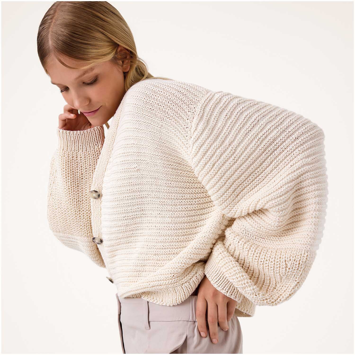 Luxury Cotton Silk Cashmere dk: Frau trägt cremefarbenen Strickpullover von Rico Design, elegant und weich.