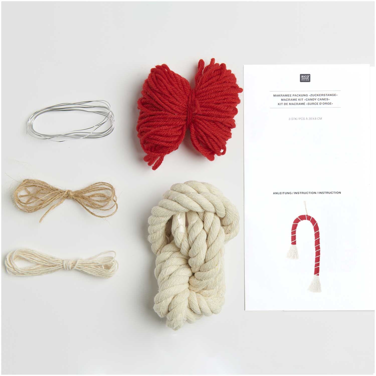 Makramee Set Zuckerstange von Rico Design mit rotem und beigem Garn, Draht und Anleitung auf weißem Hintergrund.
