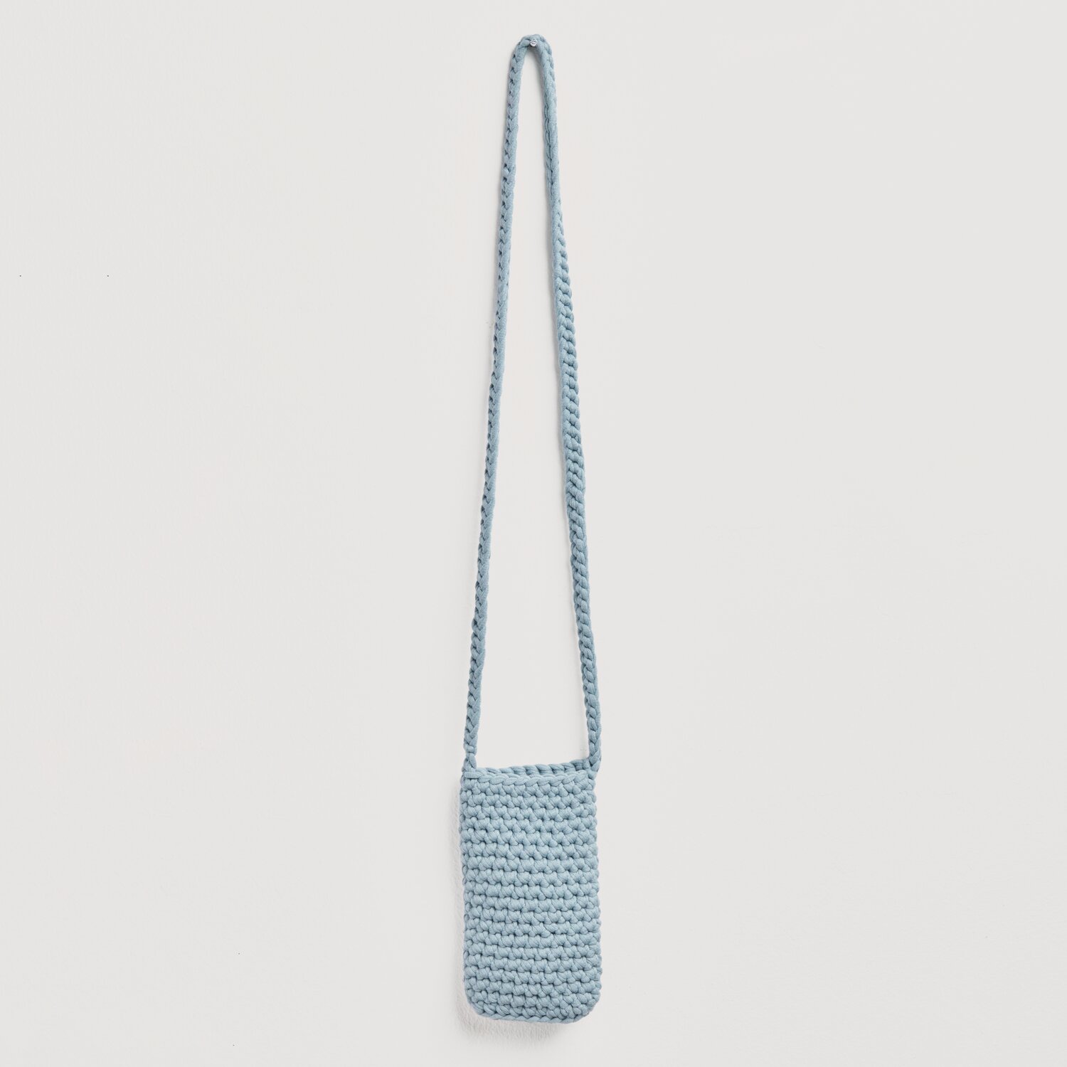 Häkelset Handytasche Modell 10: Eine blau-graue, gehäkelte Handytasche mit langem Trageriemen von Rico Design.