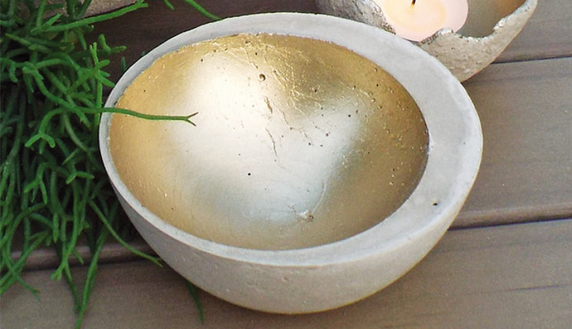 Bastelanleitung Deko-Schale aus Kreativbeton: Runde Schale mit goldener Innenseite auf Holztisch.