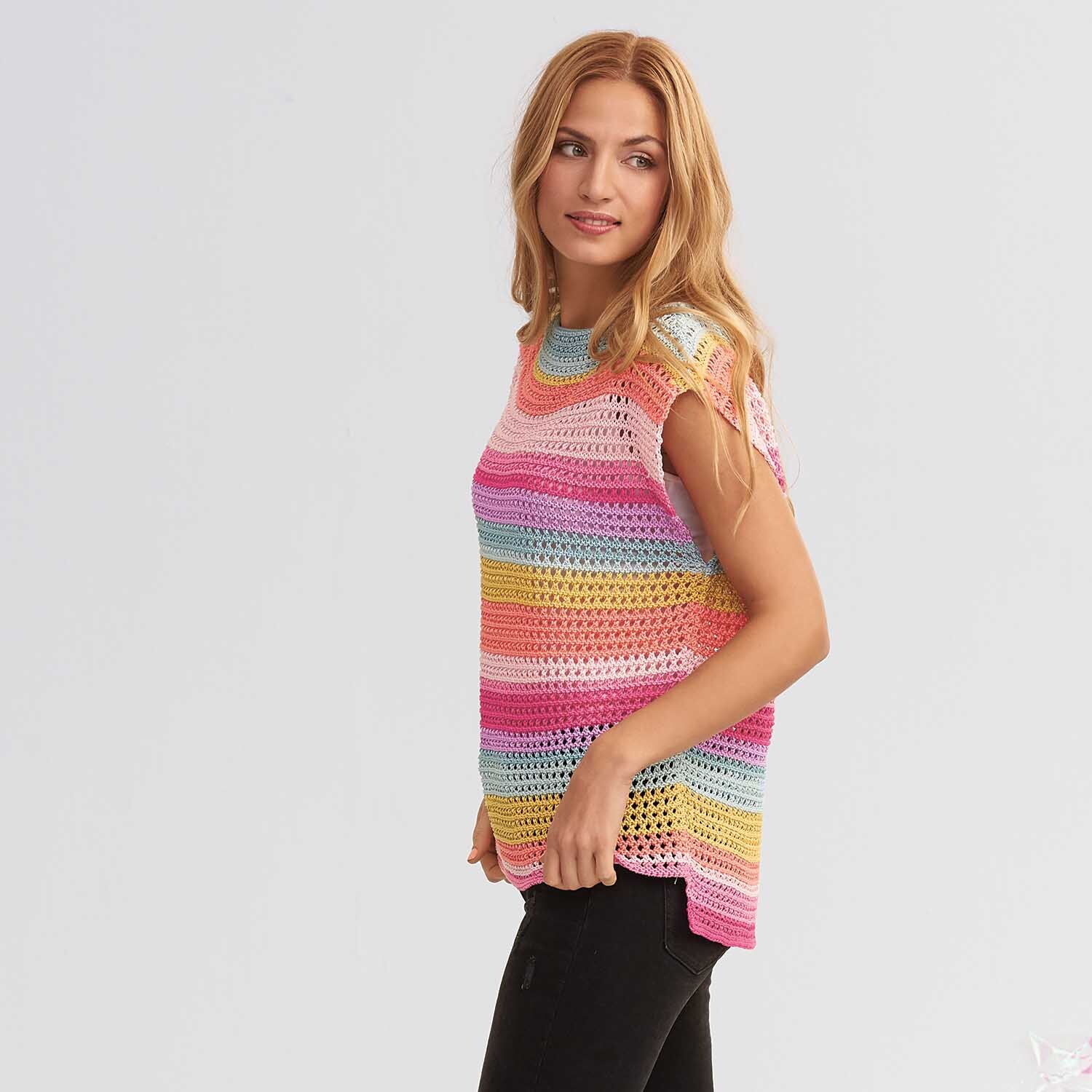Mille Fili: Frau trägt gestricktes, buntes Oberteil aus Wolle Rödel, ideal für kreative Strickprojekte.