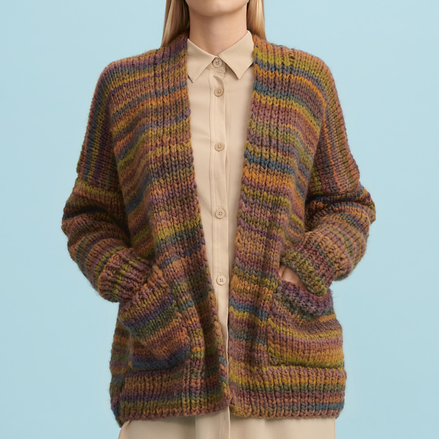 Strickanleitung Jacke aus Creative Smile: Frau trägt eine bunte, gestreifte Strickjacke vor blauem Hintergrund.