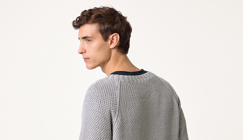 Strickanleitung Cardigan aus Luxury Organic Cotton Silk dk: Mann trägt grauen Strickcardigan, Rückansicht, schlichtes Design.