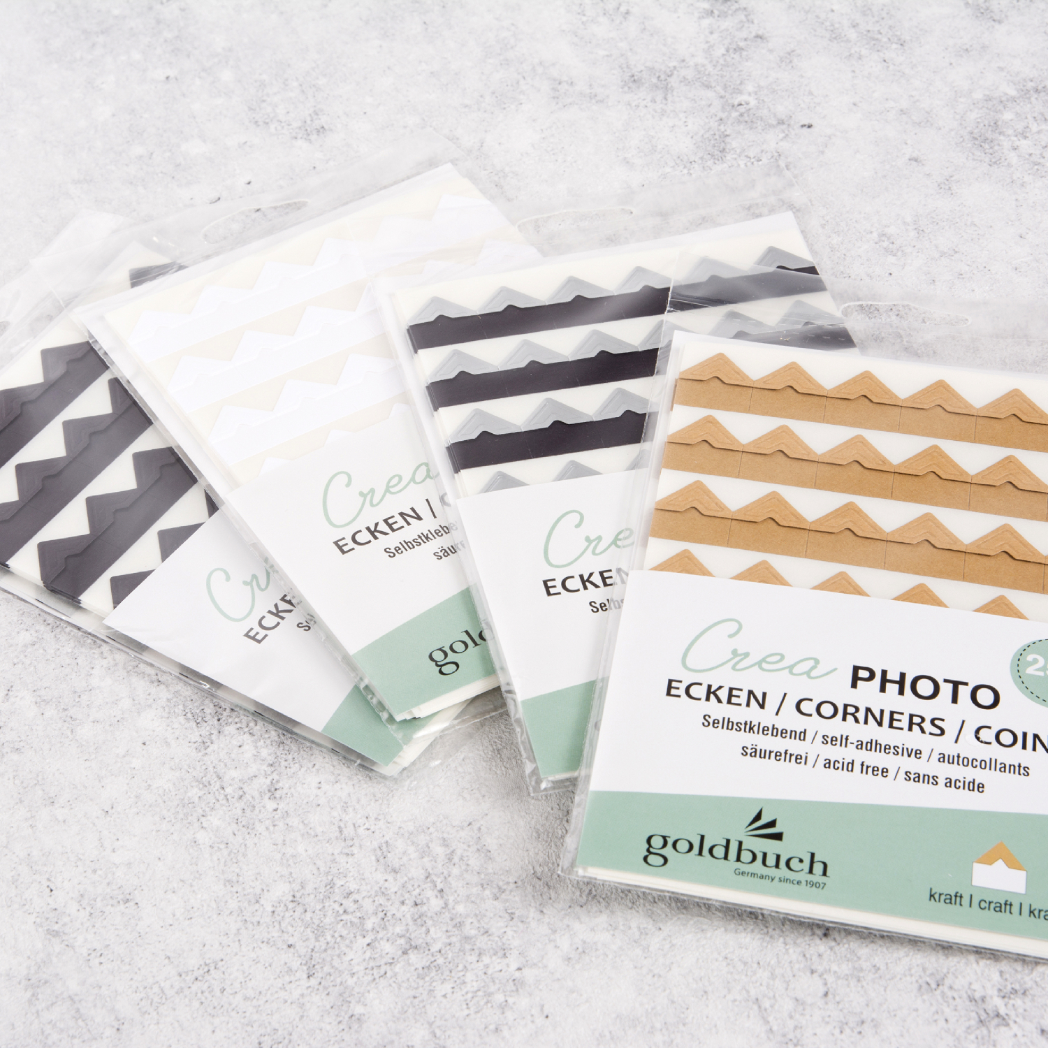 Fotoecken Crea: Vier Packungen selbstklebende Fotoecken von goldbuch in verschiedenen Farben, ideal für kreative Fotoalben.