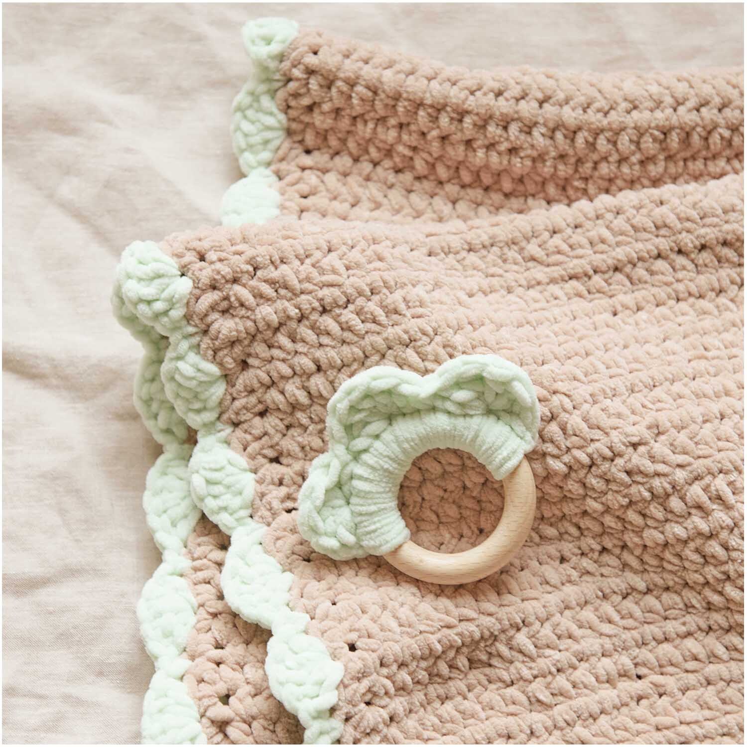 Creative Chenillove von Rico Design: Weiche, gestrickte Decke in Pastelltönen mit gehäkeltem Rand und Holzring.