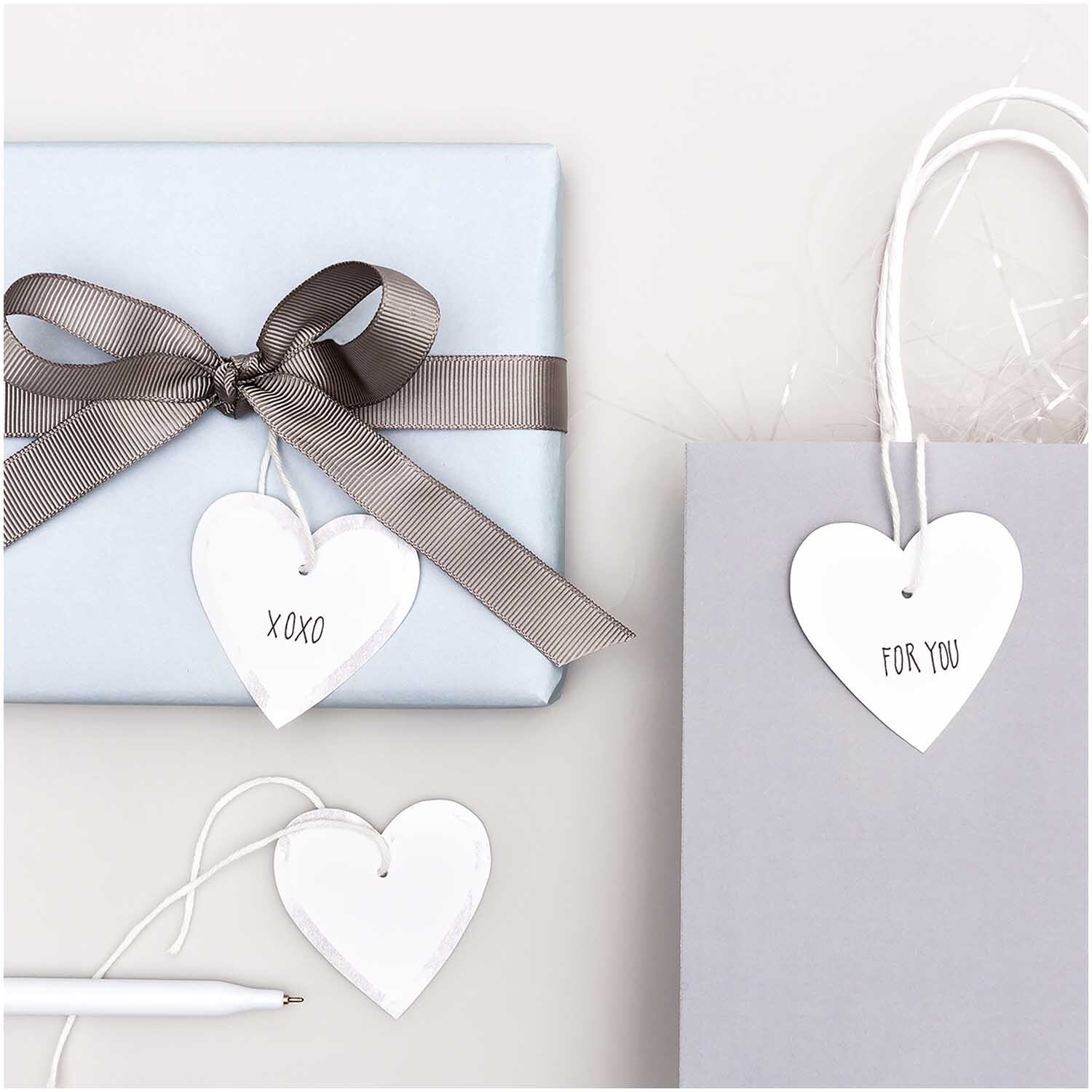 Paper Poetry Papieranhänger Herzen M 24 Stück: Herzförmige Anhänger in Weiß-Silber an Geschenken und Tüten, ideal für Dekorationen.