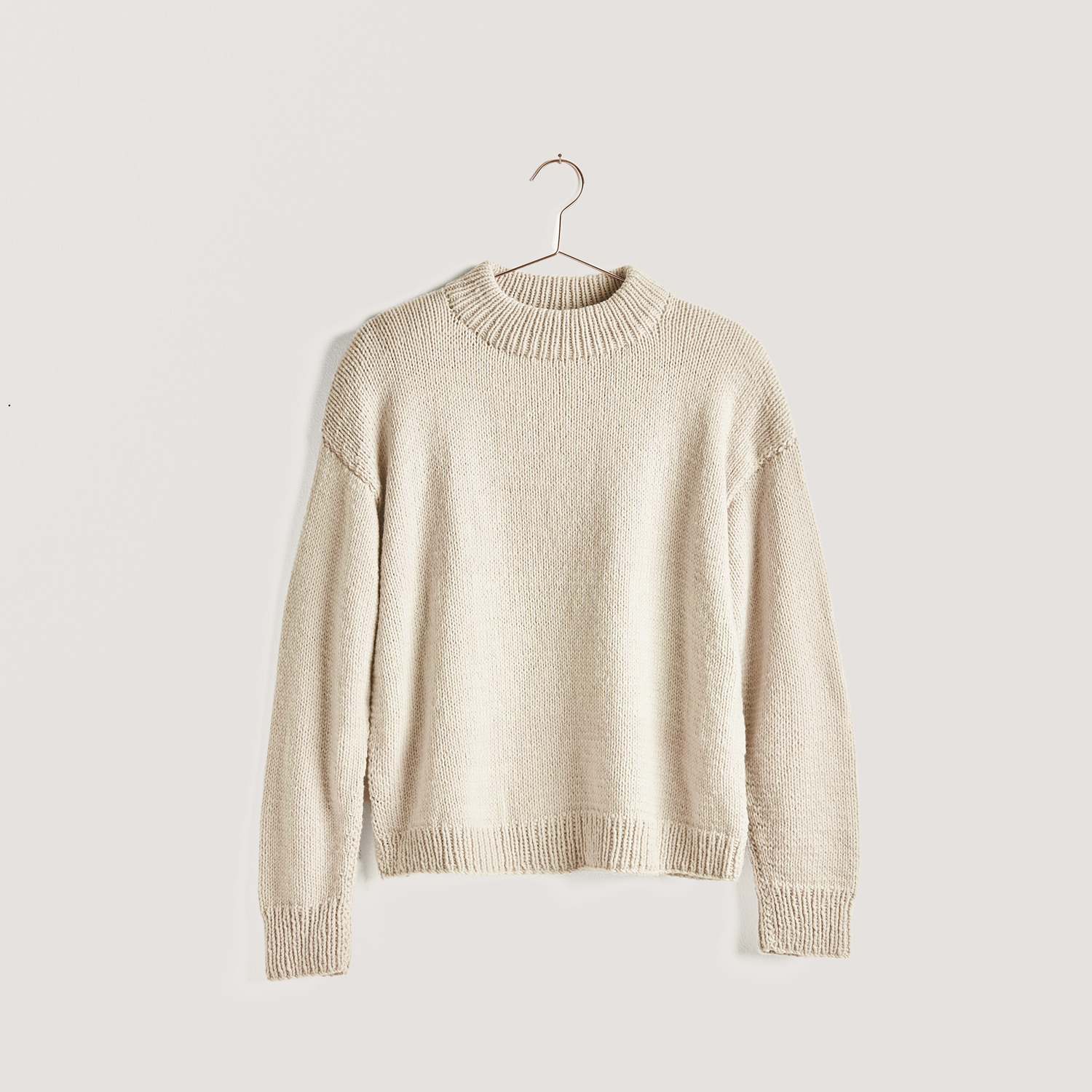 Strickset Pullover Modell 17 aus Vegan Cashmere, beige, von Rico Design auf einem Kleiderbügel.