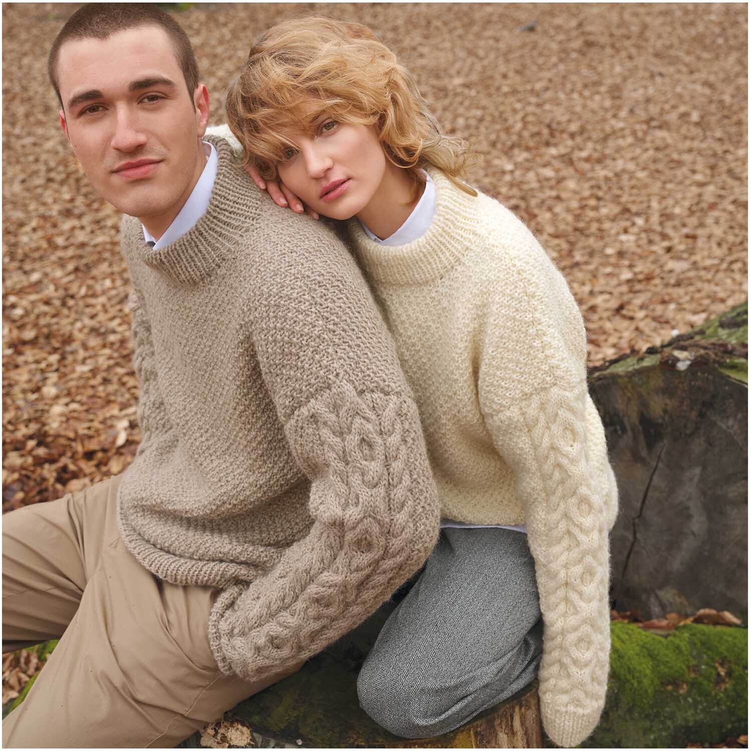 Strickset Pullover Modell 01: Zwei Personen tragen gestrickte Pullover in Beige und Creme im herbstlichen Wald.