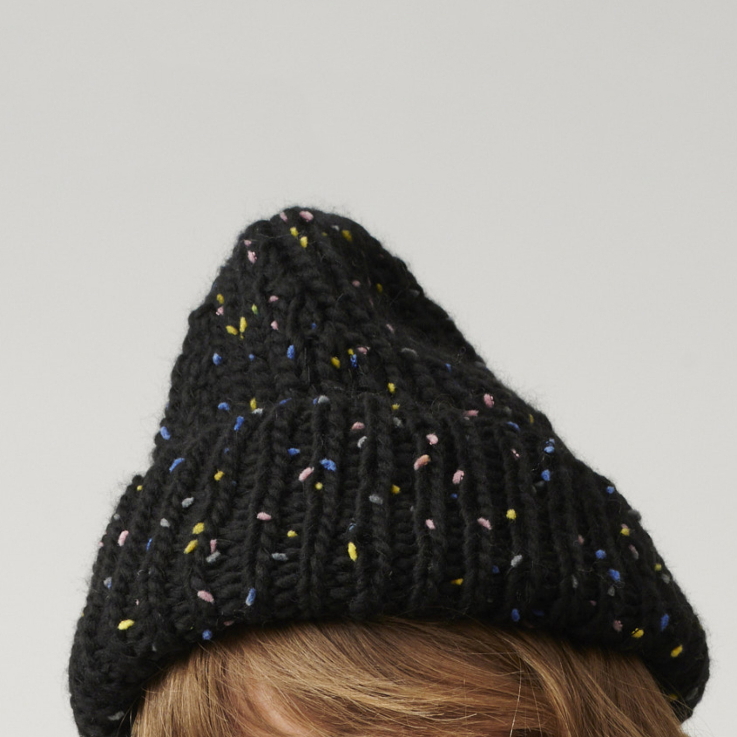 Strickanleitung Creative Jazz Up Mütze: Schwarze Mütze mit bunten Sprenkeln, die einen modernen Look verleiht. Ideal für kalte Tage.