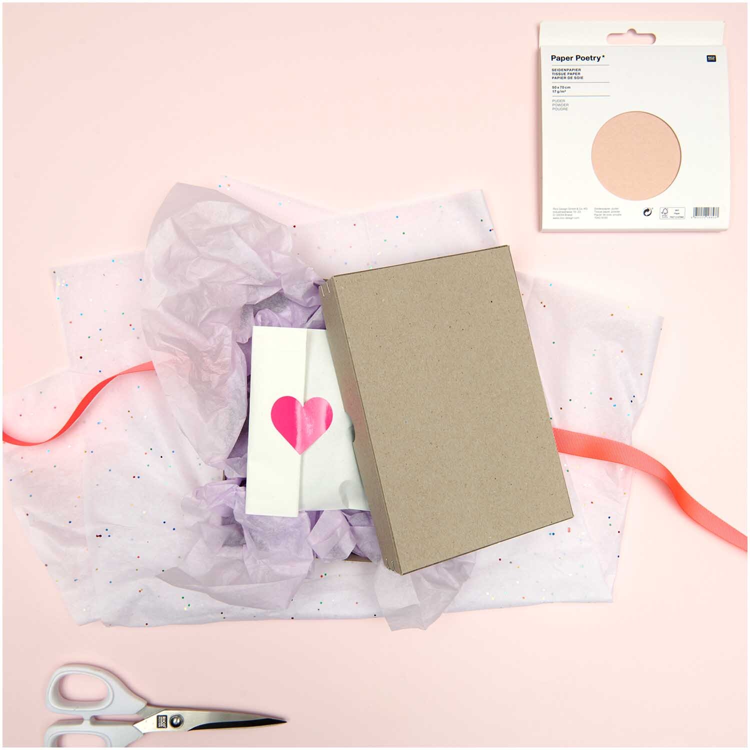 Paper Poetry Seidenpapier in Helllila, dekorativ arrangiert mit Geschenkbox, Karte und Schere auf rosa Hintergrund. Ideal für kreative Verpackungen.